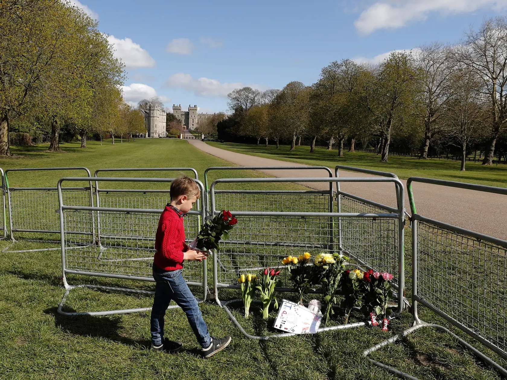 JB 2 Windsor - Chlapec kladie kvety na bariére pred Windsorským zámkom vo Windsore 15. apríla 2021. V Británii už prebiehajú prípravy poslednej rozlúčky s princom Philipom, manželom britskej kráľovnej Alžbety II., ktorý zomrel minulý piatok vo veku 99 rokov. Pohreb sa uskutoční v sobotu popoludní v areáli Windsorského zámku, informovala v pondelok stanica BBC. Pohrebné obrady sa budú konať v tamojšej kaplnke svätého Juraja o 15.00 h miestneho času (16.00 h SELČ). Celý obrad sa uskutoční výlučne 