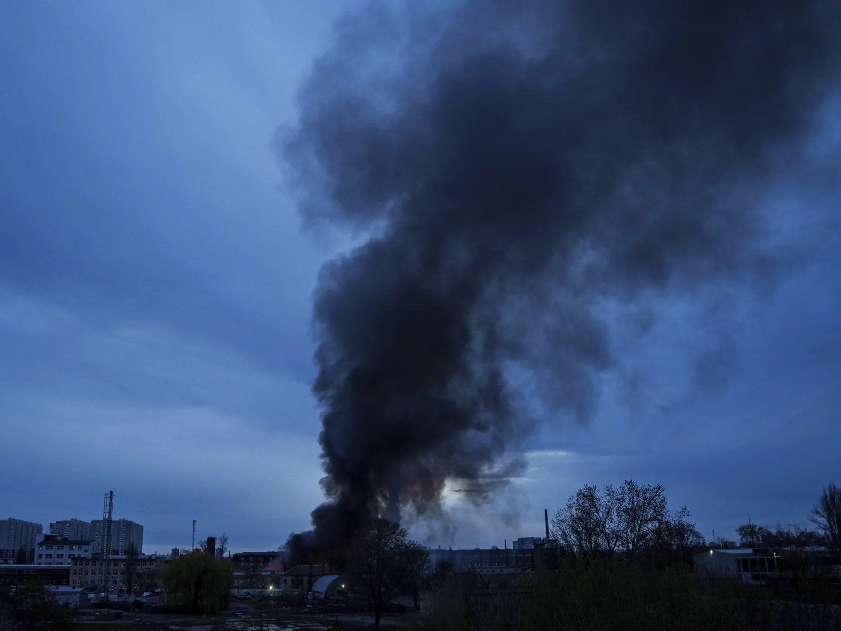 Na snímke hustý čierny dym stúpa po ruskom raketovom útoku z horiacej budovy spaľovne v priemyselnej zóne ukrajinskej metropoly Kyjev v nedeľu 6. apríla 2025.
