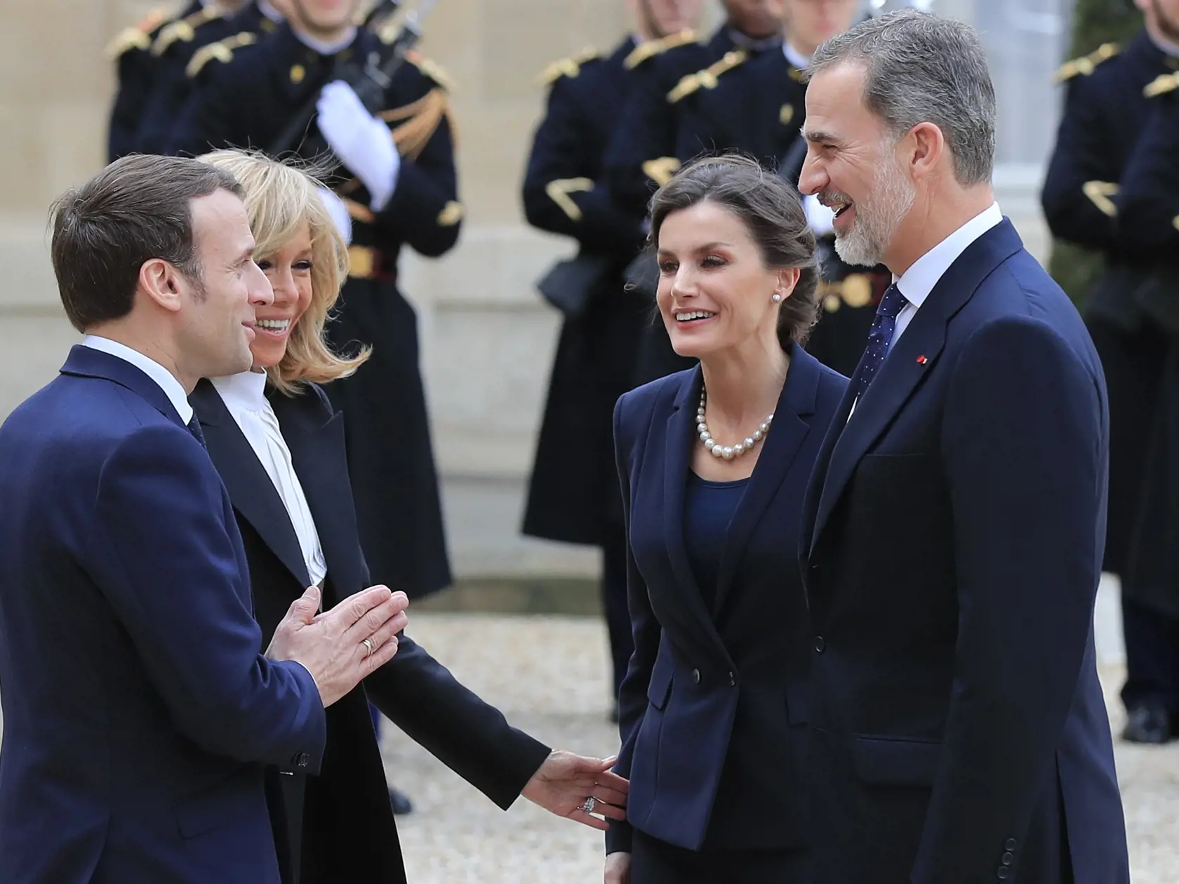Francúzsky prezident Emmanuel Macron (vľavo), jeho manželka Brigitte Macronová (druhá vľavo), španielsky kráľ Filip VI. a španielska kráľovná Letizia sa vítajú pred obedom v Elyzejskom paláci 11. marca 2020 v Paríži.