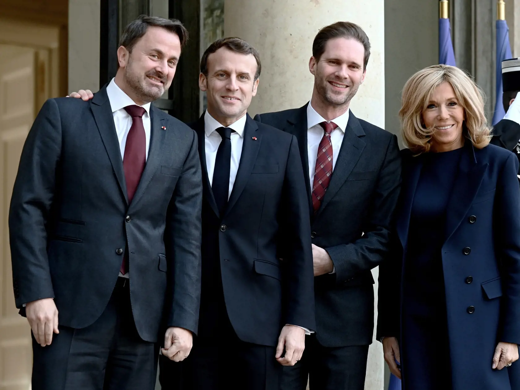 Francúzsky prezident Emmanuel Macron (druhý zľava) víta s manželkou Brigitte Macronovou (vpravo) luxemburského premiéra Xaviera Bettela (vľavo) a jeho manžela Gauthiera Destenaya (druhý sprava) počas ich stretnutia v Elyzejskom paláci v Paríži 10. januára 2020.