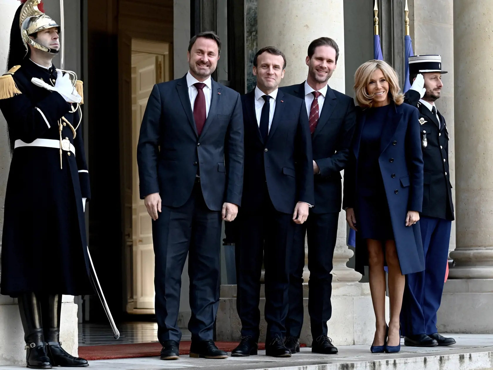 Francúzsky prezident Emmanuel Macron (druhý zľava) víta s manželkou Brigitte Macronovou (vpravo) luxemburského premiéra Xaviera Bettela (vľavo) a jeho manžela Gauthiera Destenaya (druhý sprava) počas ich stretnutia v Elyzejskom paláci v Paríži 10. januára 2020.