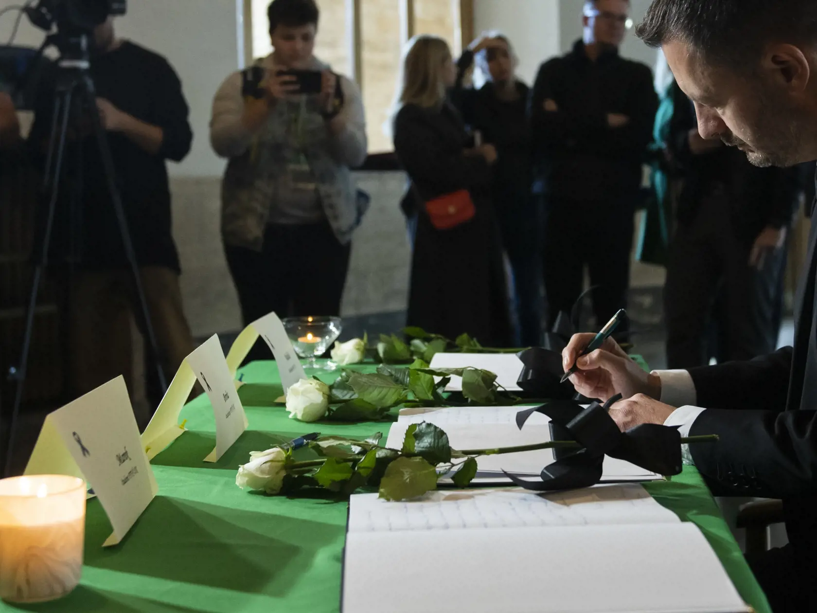 Na snímke vpravo predseda vlády SR Eduard Heger (OĽaNO) sa zapísal do kondolenčných kníh na pamiatku obetí nedeľnej tragickej dopravnej nehody v aule Univerzity Komenského v Bratislave v pondelok 3. októbra 2022. Nehoda si vyžiadala piatich mŕtvych a päť zranených. FOTO  TASR - Martin Baumann
