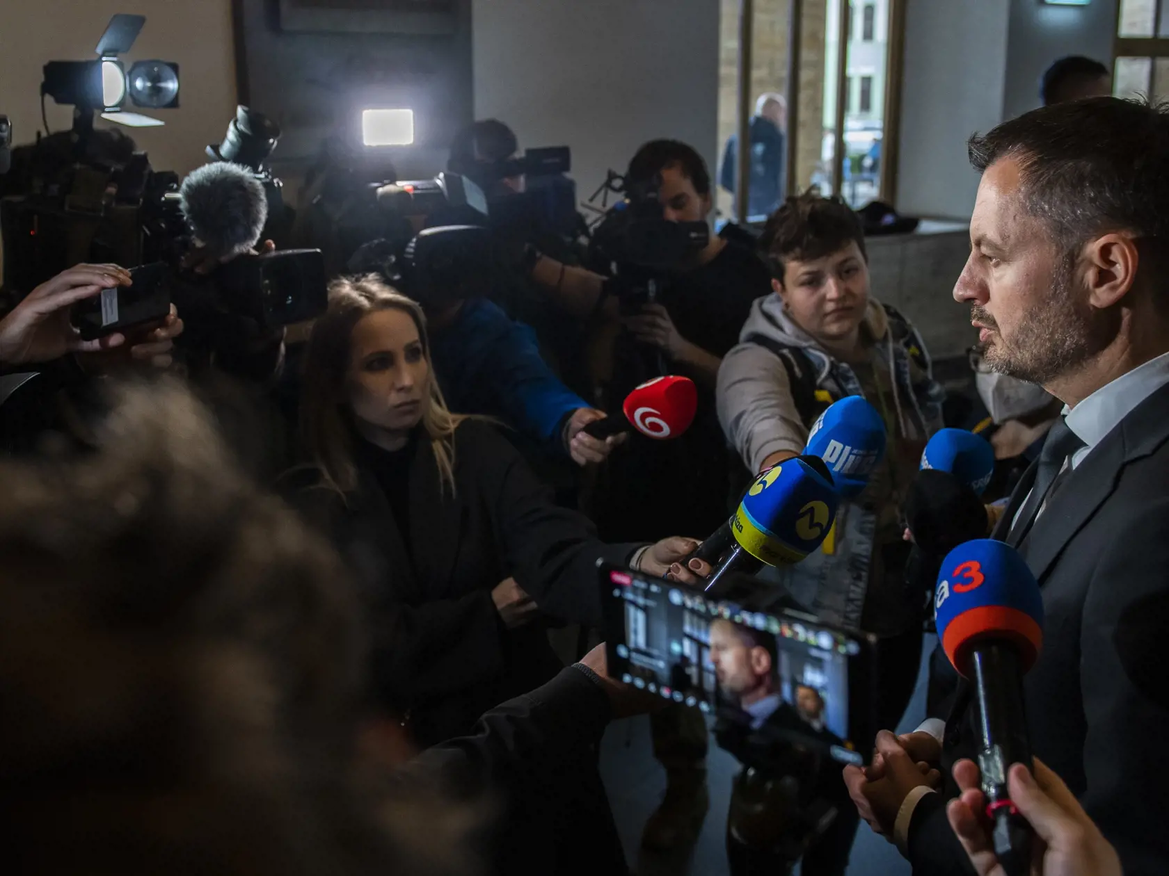 Na snímke vpravo predseda vlády SR Eduard Heger (OĽaNO) poskytuje rozhovor médiám po tom, ako sa zapísal do kondolenčných kníh na pamiatku obetí nedeľnej tragickej dopravnej nehody v aule Univerzity Komenského v Bratislave v pondelok 3. októbra 2022. Nehoda si vyžiadala piatich mŕtvych a päť zranených. FOTO  TASR - Martin Baumann