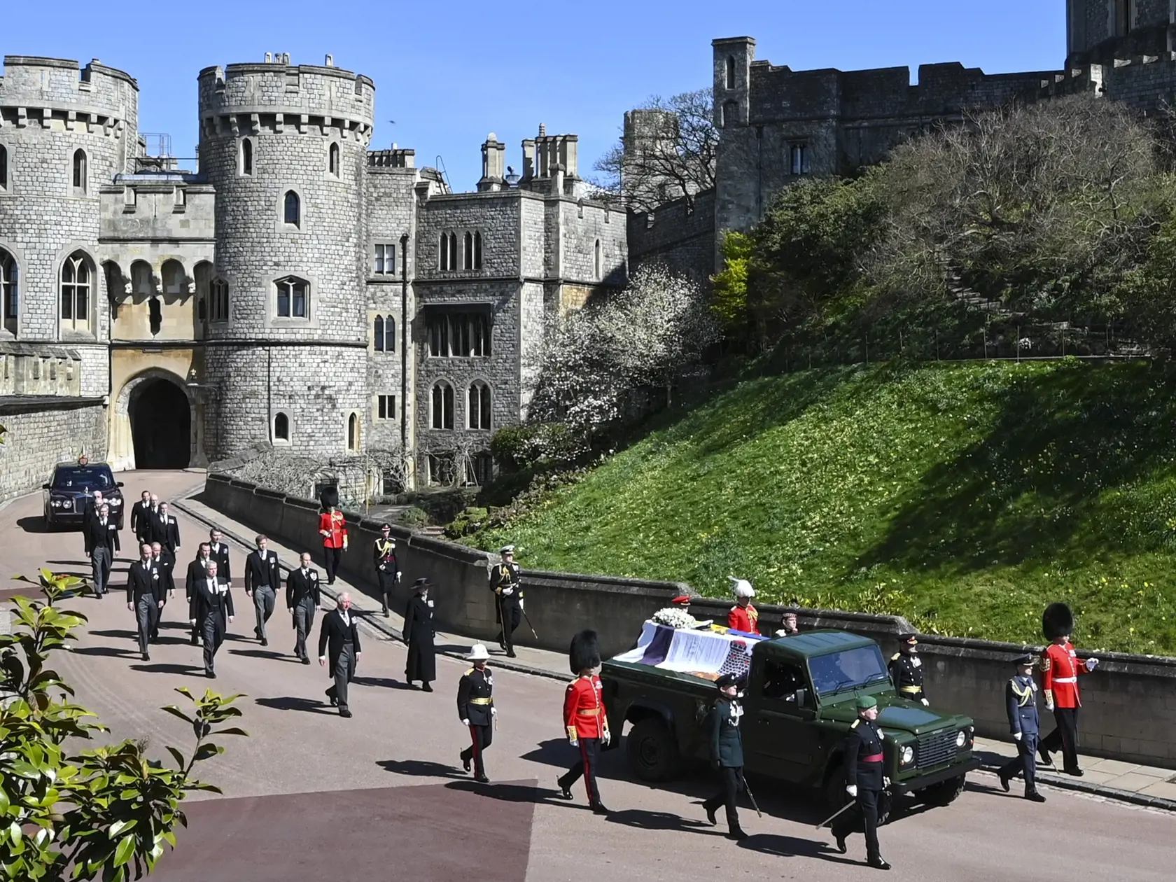 JB 60 Windsor - Britský princ Charles (vpredu vľavo), princezná Anne, princ Andrew. princ Edward, princ William, Peter Phillips, princ Harry,  Tim Laurence a britská kráľovná Alžbeta II. v aute vzadu sprevádzajú rakvu pri prechádzaní okolo veže Round Tower počas pohrebu britského princa Philipa, manžela britskej kráľovnej Alžbety II., ktorý zomrel minulý piatok vo veku 99 rokov, v areáli Windsorského zámku vo Windsore 17. apríla 2021. Philipovo telo previezli zo súkromnej kaplnky pred vchod hrad
