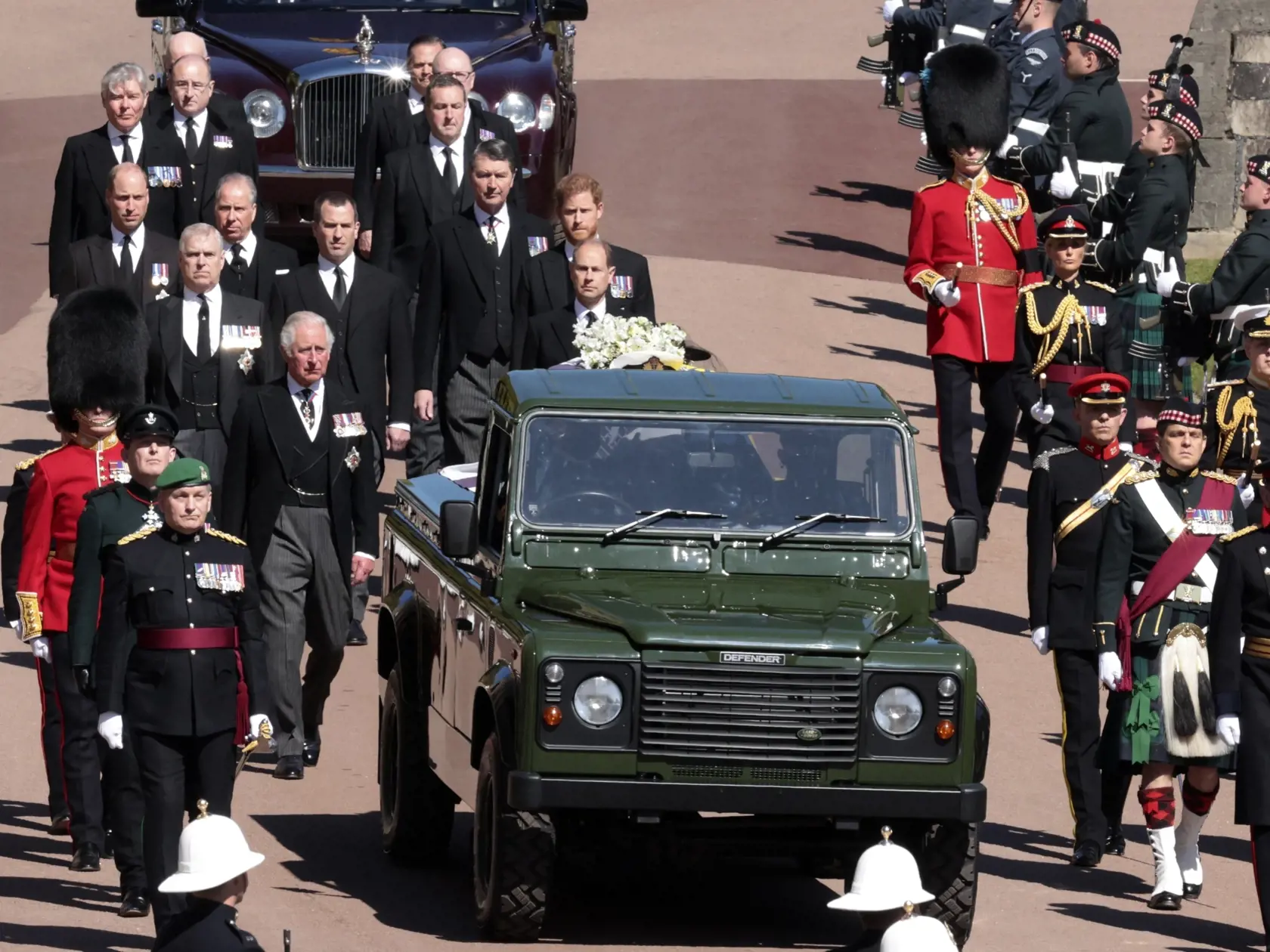 JB 61 Windsor - Členovia kráľovskej rodiny britský princ Charles (vpredu vľavo), princezná Anne, princ Andrew. princ Edward, princ William, Peter Phillips, princ Harry,  Tim Laurence a britská kráľovná Alžbeta II. v aute vzadu sprevádzajú rakvu pri prechádzaní okolo veže Round Tower počas pohrebu britského princa Philipa, manžela britskej kráľovnej Alžbety II., ktorý zomrel minulý piatok vo veku 99 rokov, v areáli Windsorského zámku vo Windsore 17. apríla 2021. Philipovo telo previezli zo súkrom