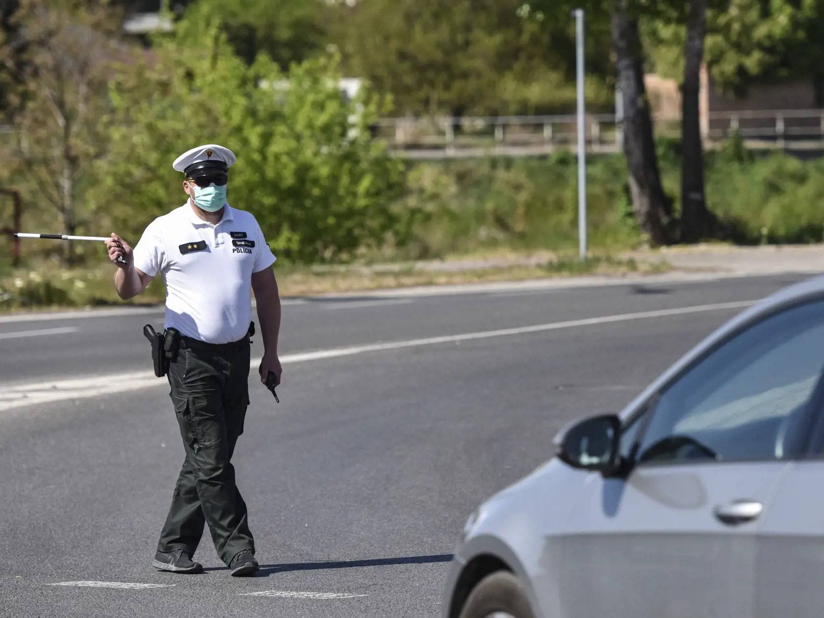 Na snímke príslušník Policajného zboru SR odkláňa dopravu na kruhovom objazde, v dôsledku požiaru na Ráztočnej ulici vo Vrakuni 25. apríla 2020 v Bratislave. FOTO TASR - Pavol Zachar
