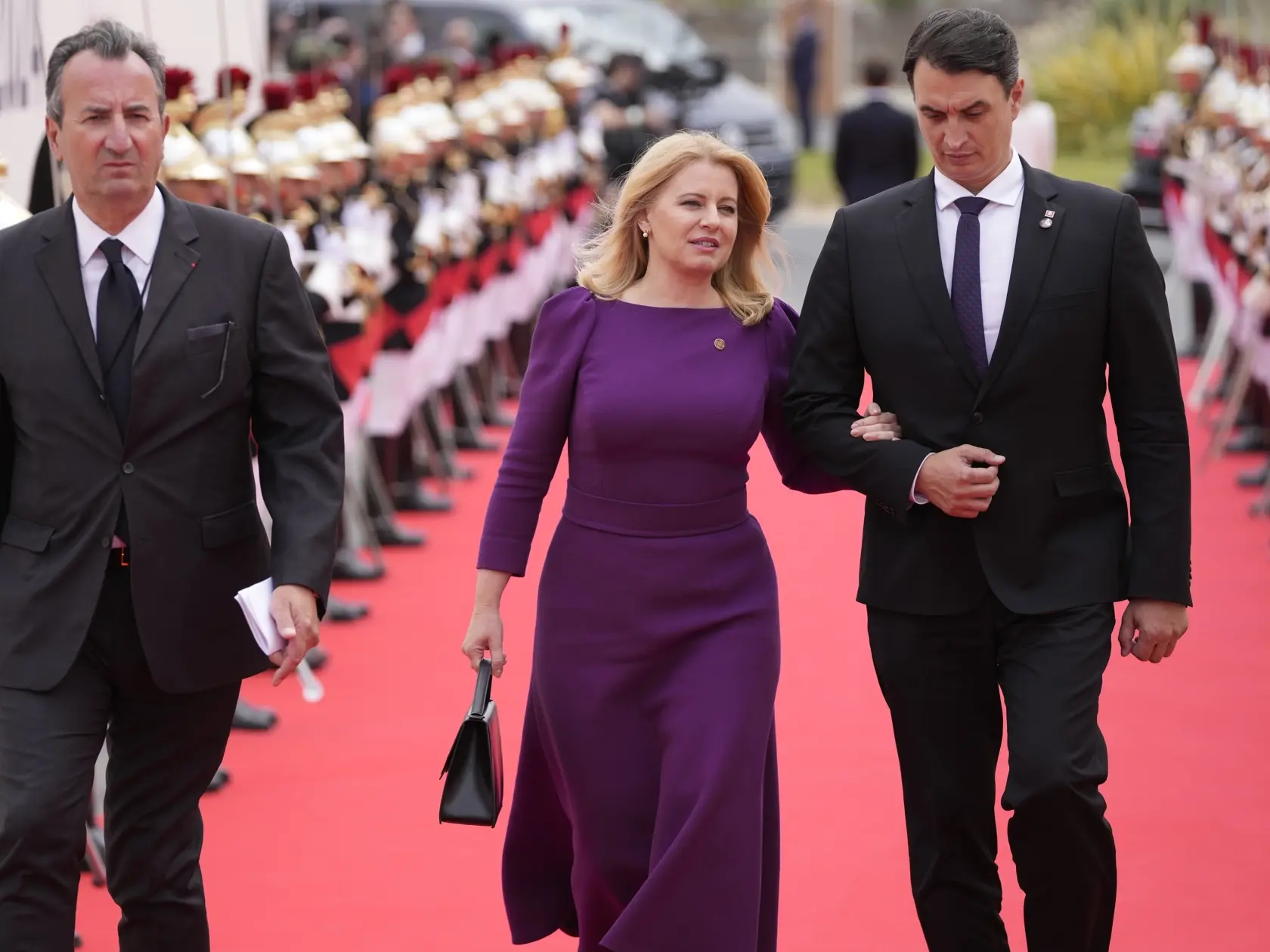 Prezidentka SR Zuzana Čaputová (uprostred) a jej partner Juraj Rizman (vpravo) prichádzajú na medzinárodnú ceremóniu počas spomienkových osláv pri príležitosti 80. výročia vylodenia spojeneckých vojsk v Normandii, na pláži Omaha Beach vo francúzskom meste Saint-Laurent-sur-Mer v Normandii.