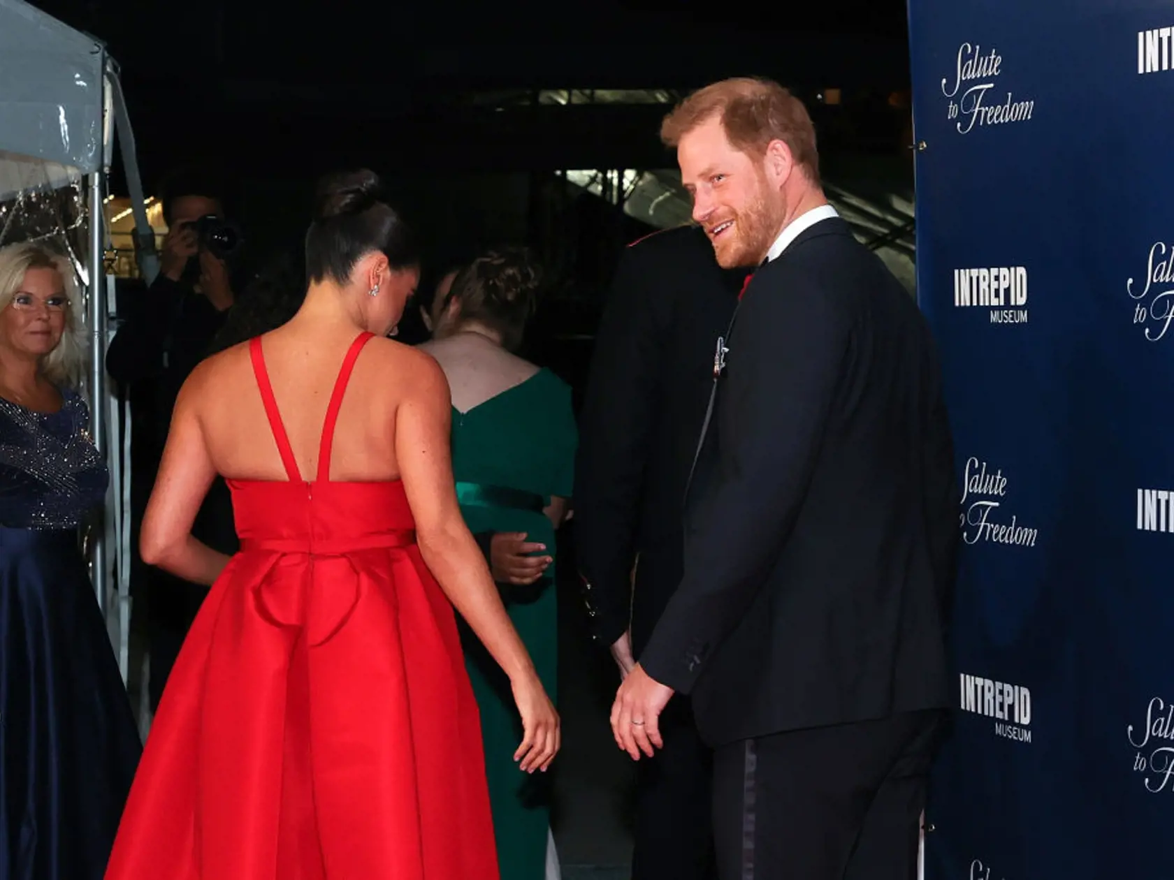 Meghan Markle pútala pohľady v ohnivo červených šatách.