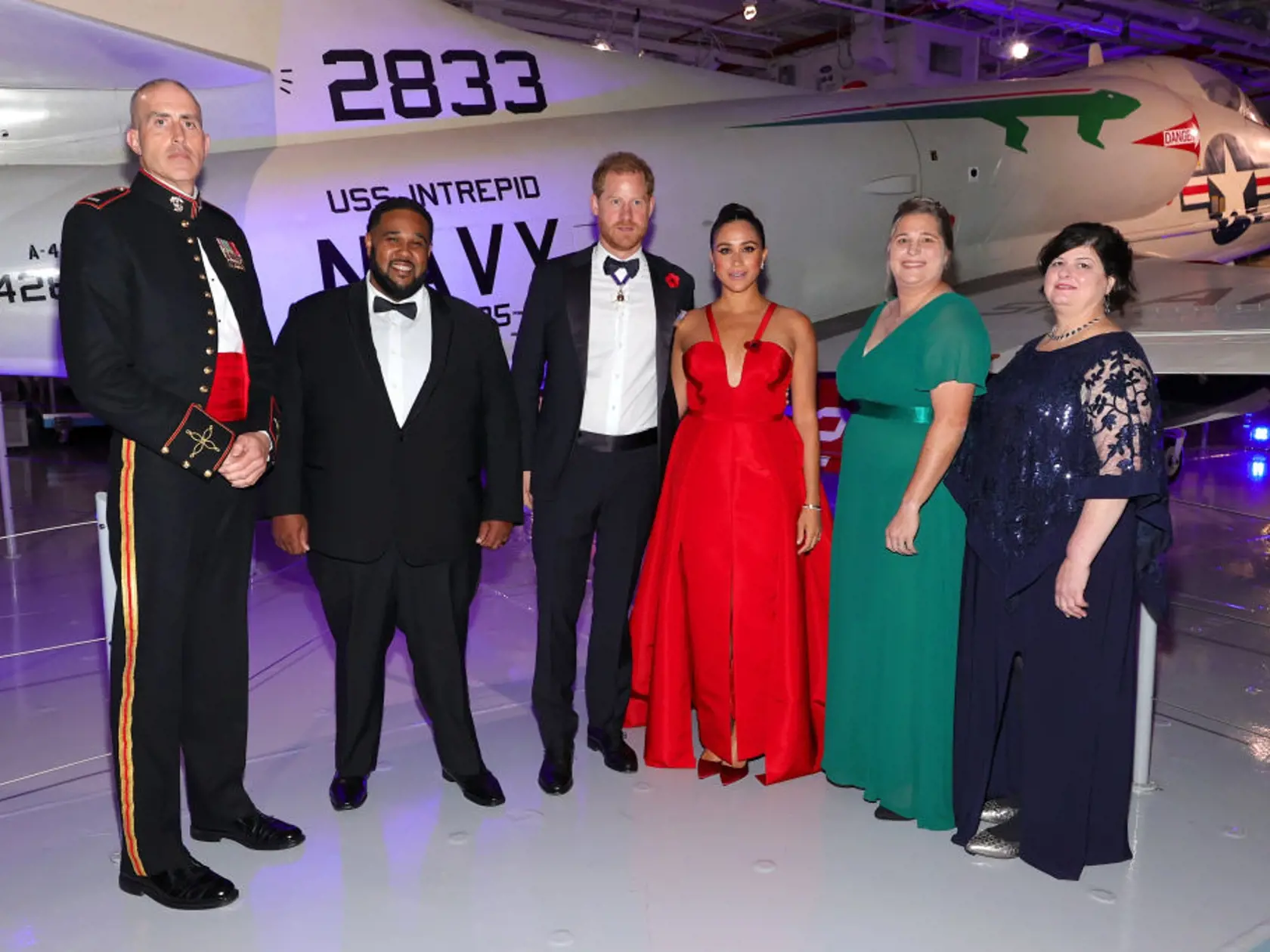 Meghan Markle pútala pohľady v ohnivo červených šatách.