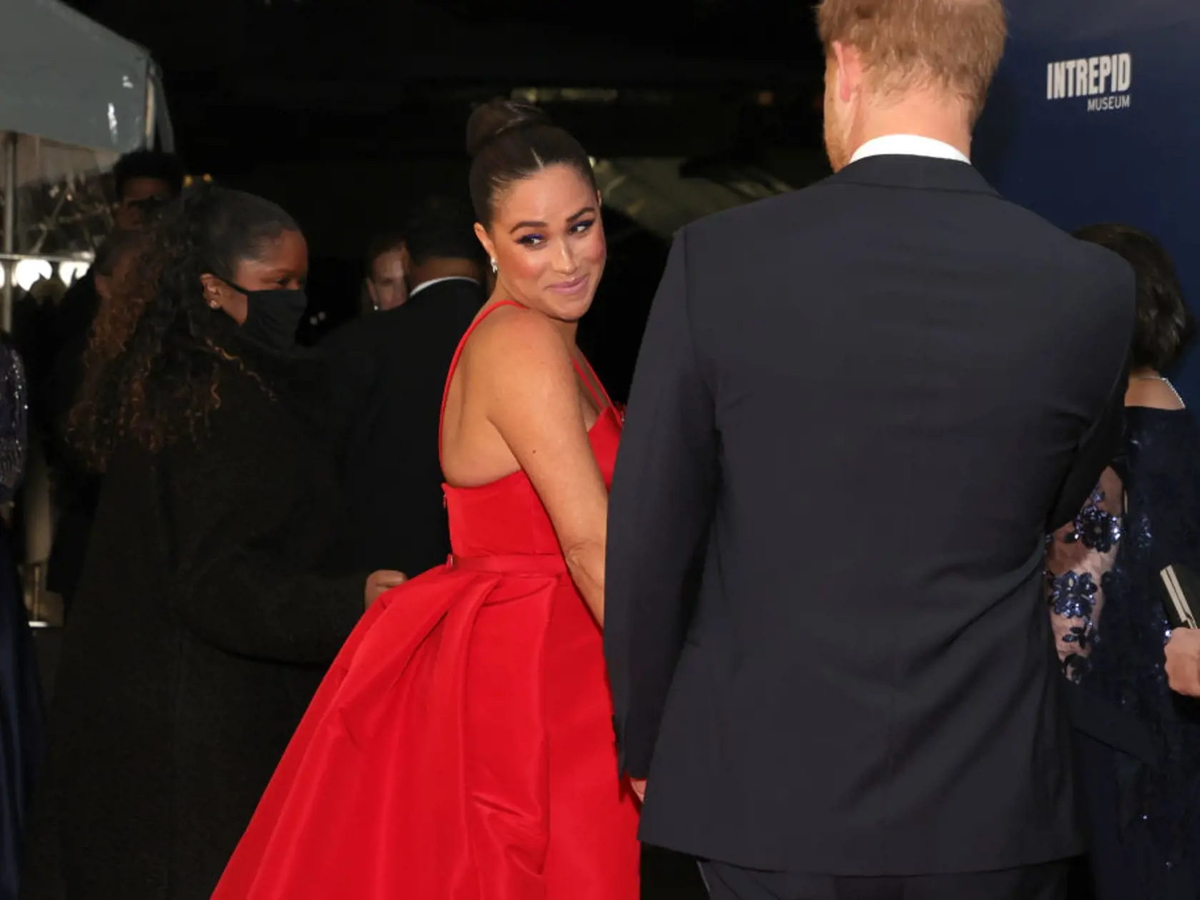 Meghan Markle pútala pohľady v ohnivo červených šatách.