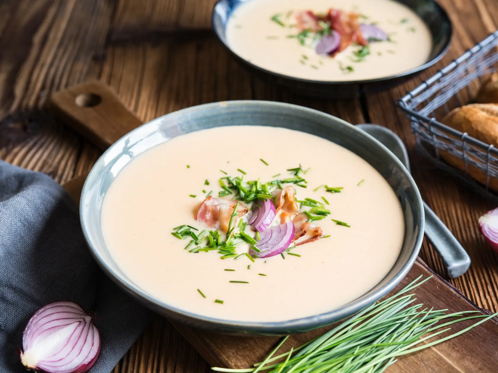 Demikat, classic Slovakian creamy sheep cheese soup topped with roasted bacon and fresh chives on wooden background