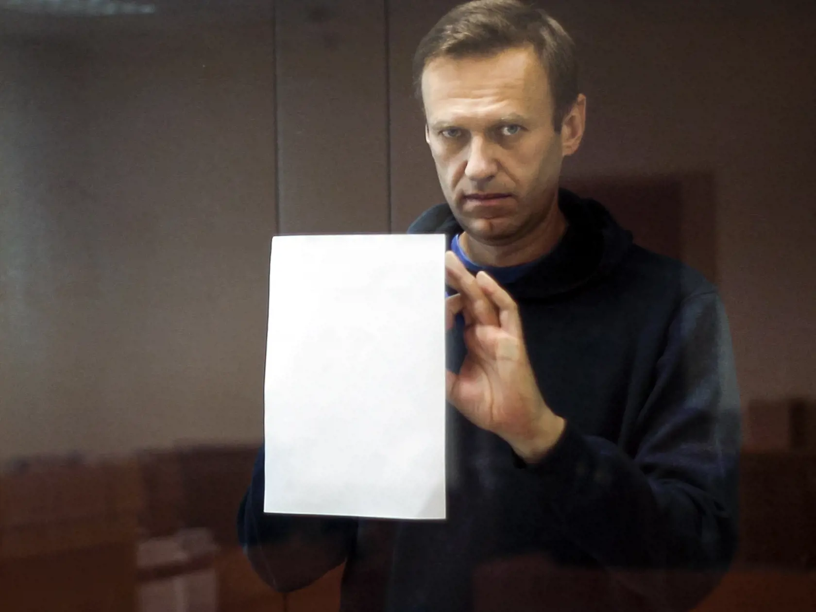 Na snímke zverejnenej moskovským Babuškinským obvodným súdom vodca ruskej opozície Alexej Navaľnyj si píše poznámky v ochrannej klietke počas pojednávania v kauze ohovárania veterána druhej svetovej vojny, ktorého sa údajne dopustil opozičný politik v Moskve v utorok 16. februára 2021.