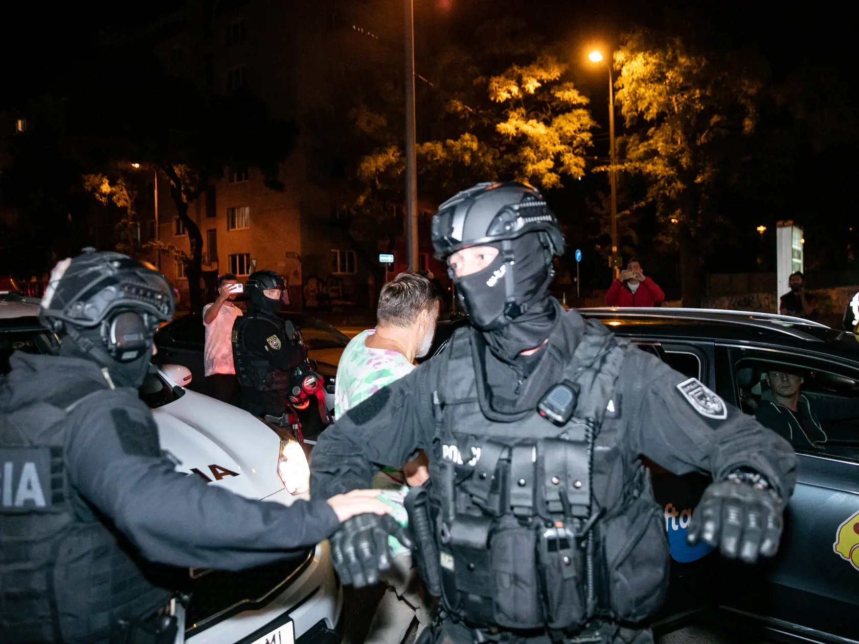 Obvinený šofér smrtiaceho auta Dušan Dedeček (v svetlom tričku) po rozhodnutí Okresného súdu že bude stíhaný na slobode, utiekol pred novinármi.