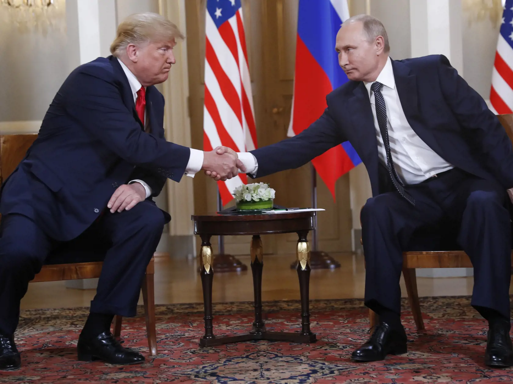 Na snímke vpravo ruský prezident Vladimir Putin a vľavo americký prezident Donald Trump si podávajú ruky na úvod prvého summitu v prezidentskom paláci vo fínskej metropole Helsinki 16. júla 2018. 