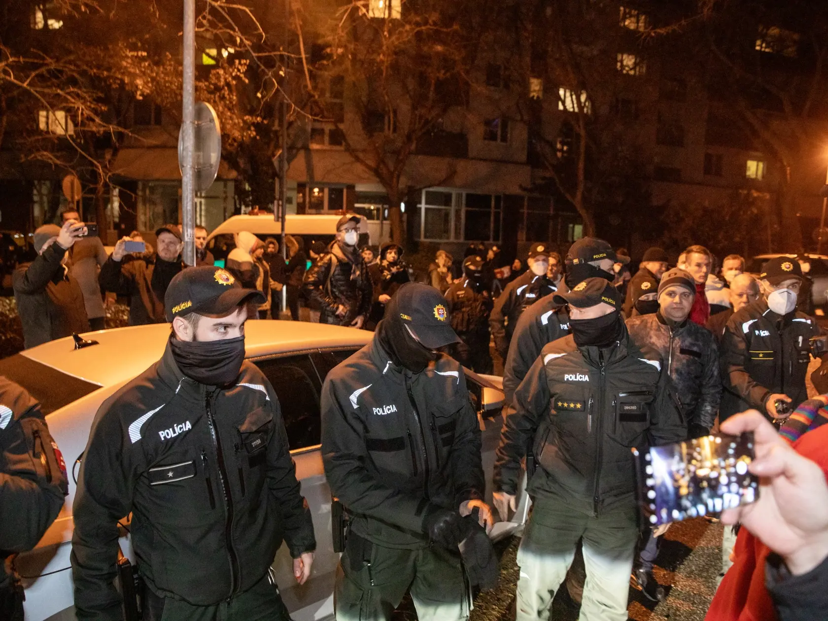 Na snímke sú príslušníci policajného zboru SR pred autom Roberta Fica potom, čo bolo z jedného demonštatov poškodené.