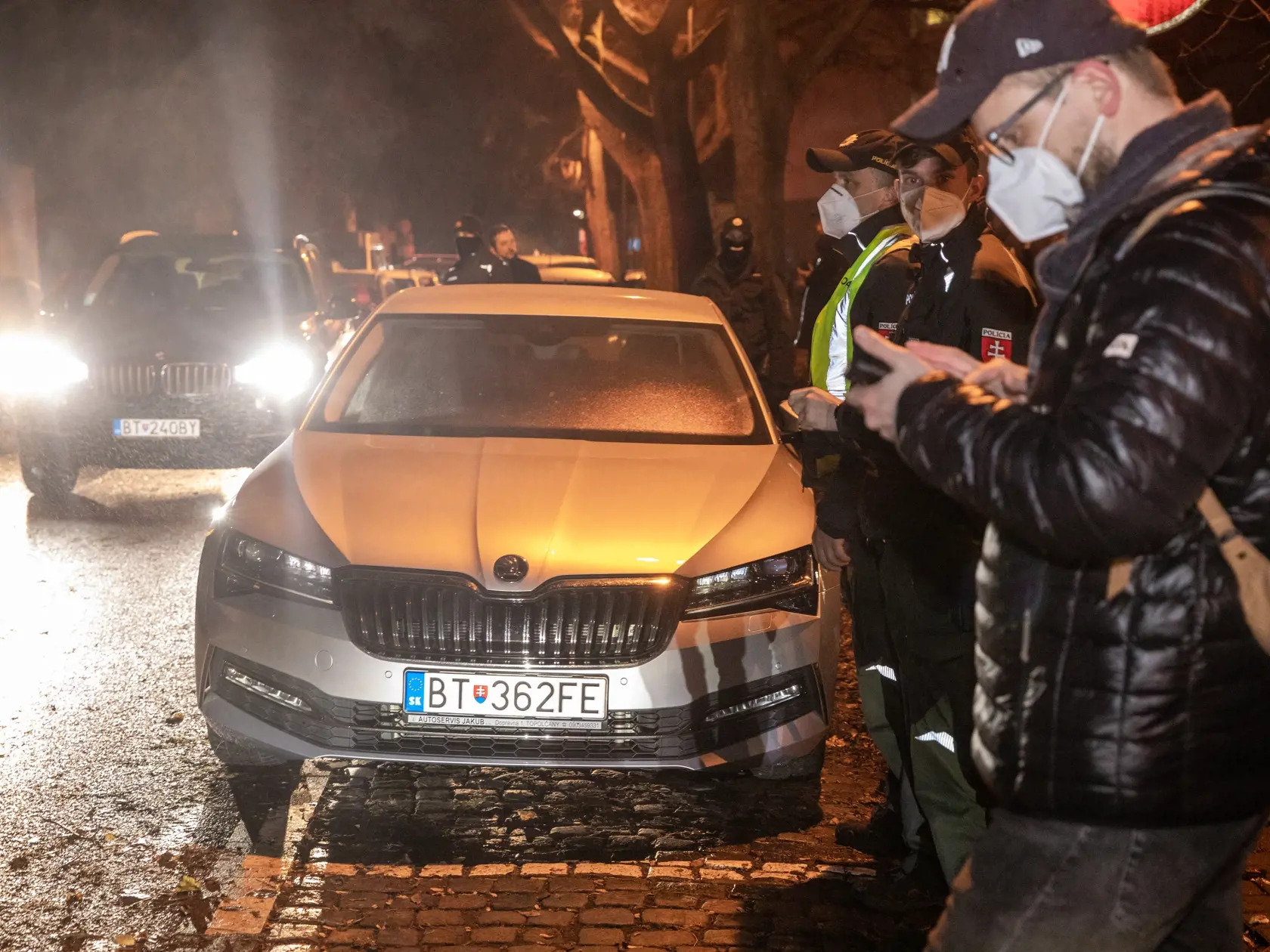 Na snímke sú príslušníci policajného zboru SR pred autom Roberta Fica potom, čo bolo z jedného demonštatov poškodené.