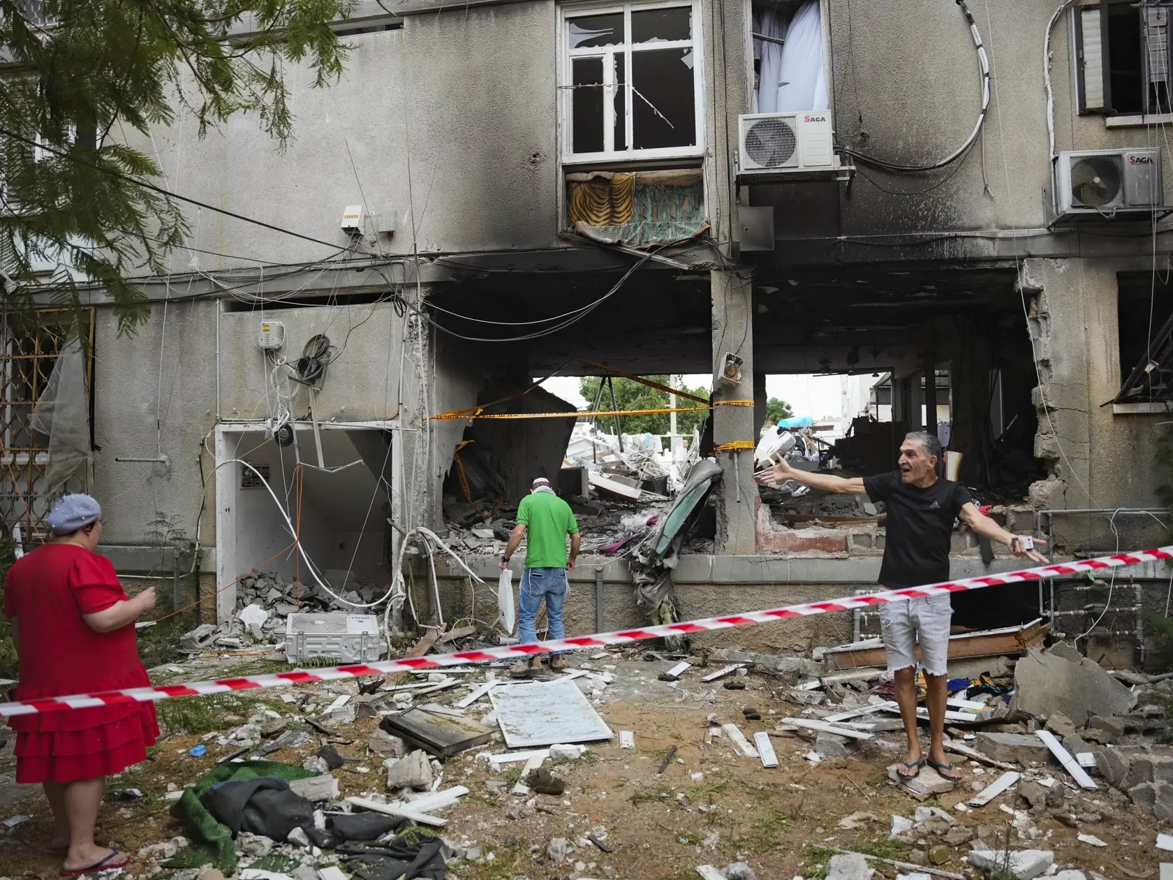 KK13 Aškelon - Izraelčania kontrolujú poškodenú obytnú budovu po zásahu raketou vypálenou z pásma Gazy v izraelskom meste Aškelon 9. októbra 2023. Islamistické hnutie Hamas spustilo v sobotu ráno z pásma Gazy rozsiahle raketové útoky na Izrael, pričom militanti z tohto hnutia súčasne prenikli cez hranice. Izrael reagoval protiútokmi. Boje a raketová streľba naďalej pokračujú. Izrael, USA a EÚ považujú Hamas za teroristickú organizáciu. FOTO TASR/AP

Israelis inspect a damaged residential buildin