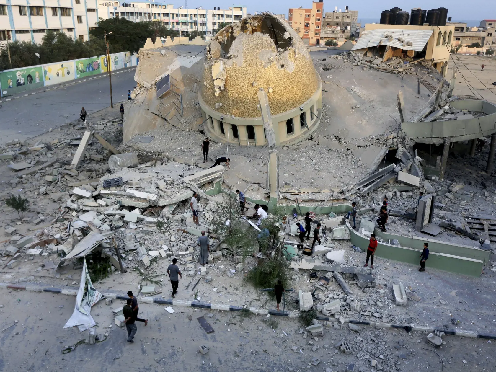 JB 76 Chán Júnis - Palestínčania stoja pred zničenou mešitou po izraelskom leteckom útoku v meste Chán Júnis, v pásme Gazy 8. októbra 2023. Počet obetí konfliktu v pásme Gazy sa v nedeľu zvýšil na 313. Izraelská armáda pokračuje v evakuácii civilistov. TASR správu prevzala z agentúr AP a AFP. Ministerstvo zdravotníctva v pásme Gazy hlásilo 313 obetí a najmenej 1990 zranených z radov Palestínčanov. Medzi obeťami a zranenými sú aj deti. Hlavný hovorca izraelskej armády Daniel Hagari pre AP v nedeľ