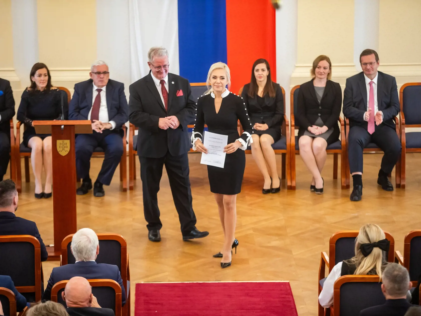 Saková si preberá osvedčenie.