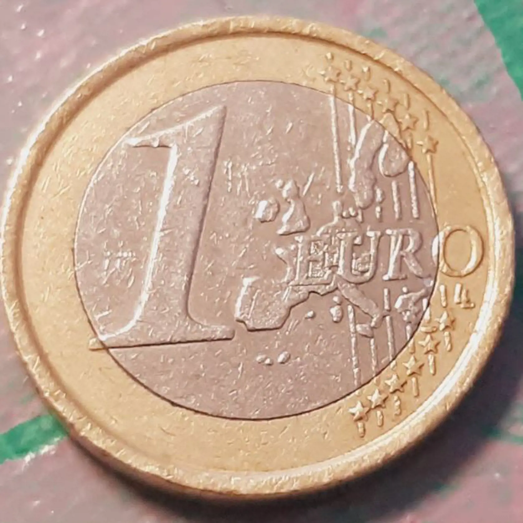 Vzácna jednoeurová mince z roku 2002, ktorá je zle razená. Jej hodnota sa pohybuje od 500 eur vyššie.