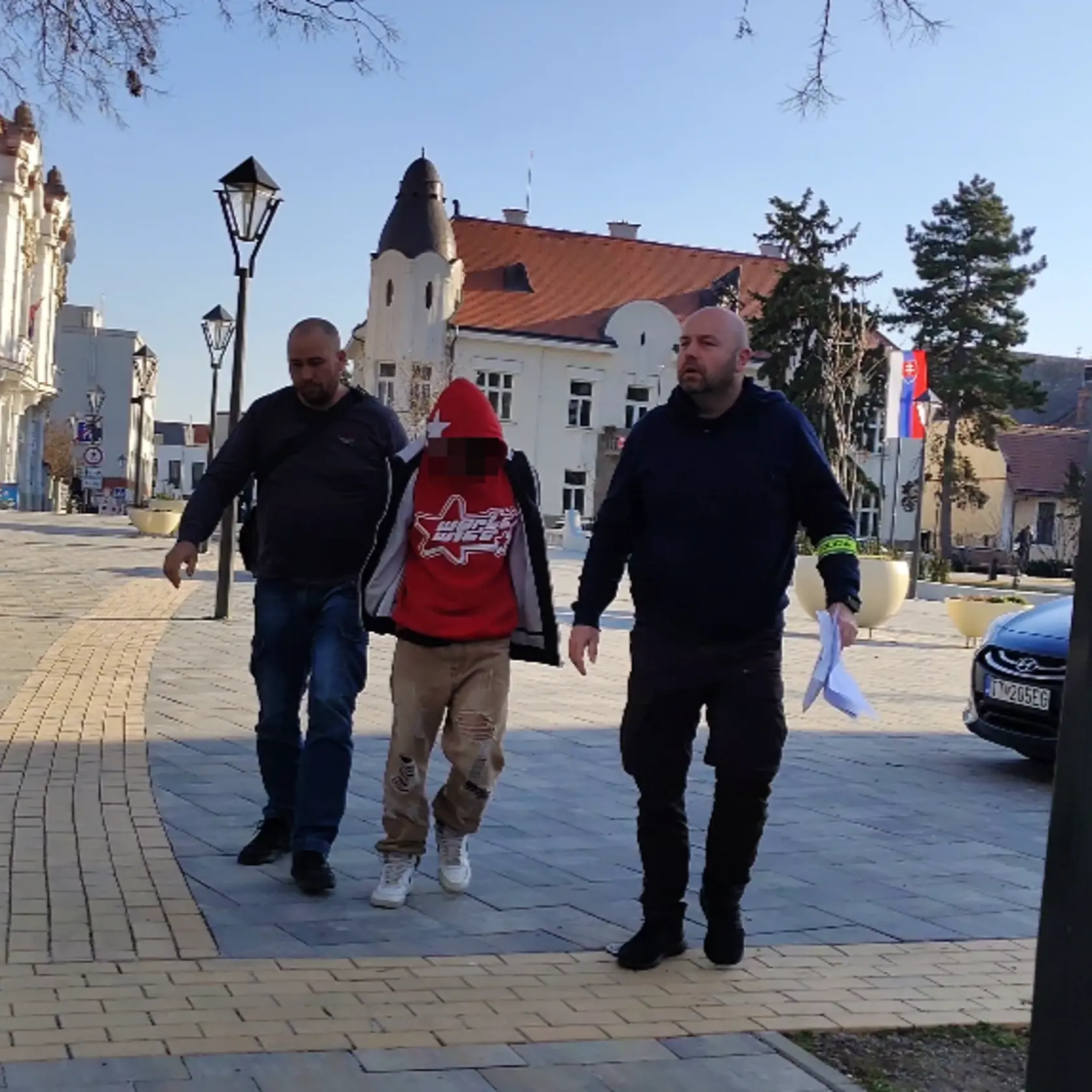 Policajná eskorta privádza na súd v Trnave 15-ročného mladíka, ktorý mal v Piešťanoch dobiť 18-ročného Tomáša teleskopickou palicou.