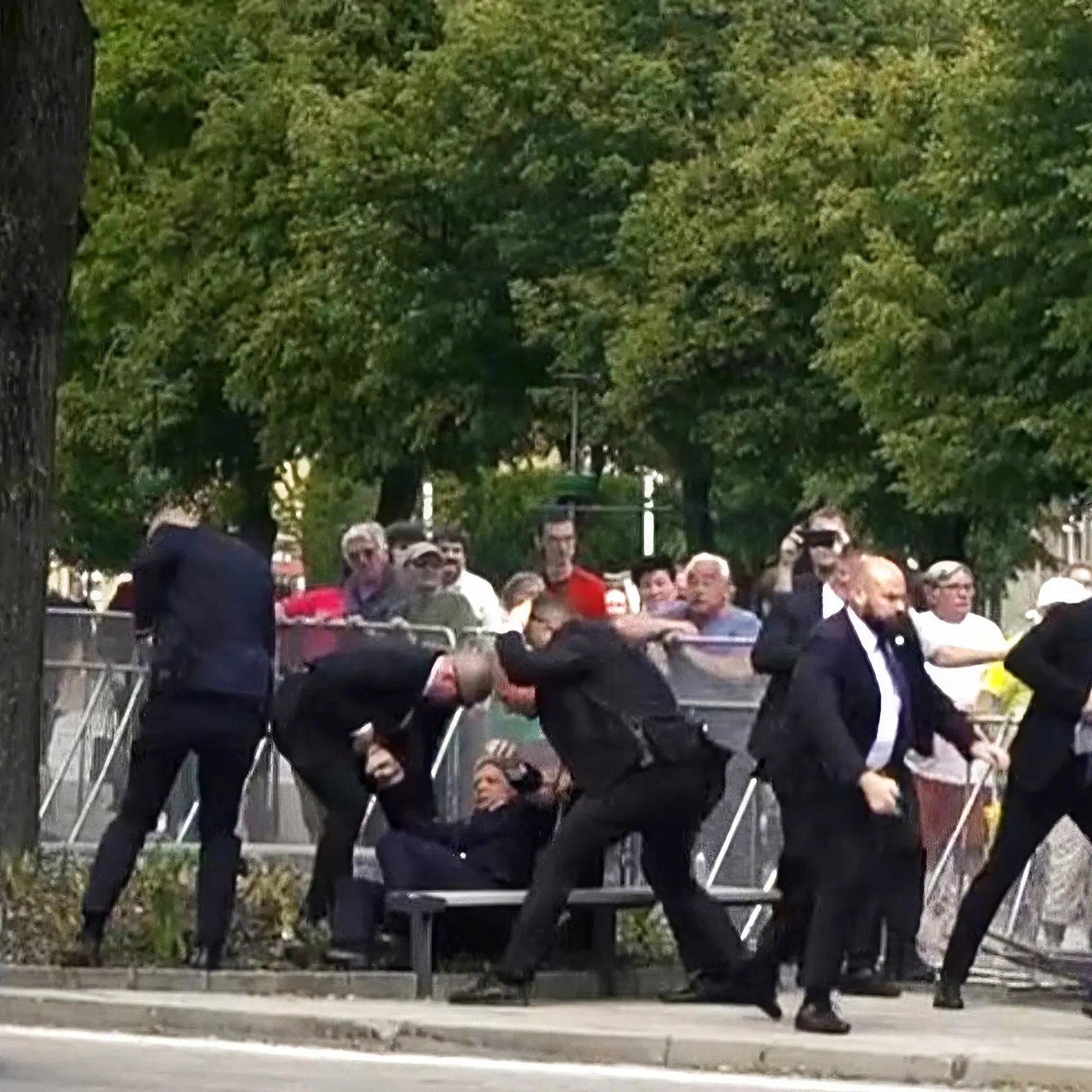 Ochrankári dvíhajú na zemi ležiaceho predsedu vlády.