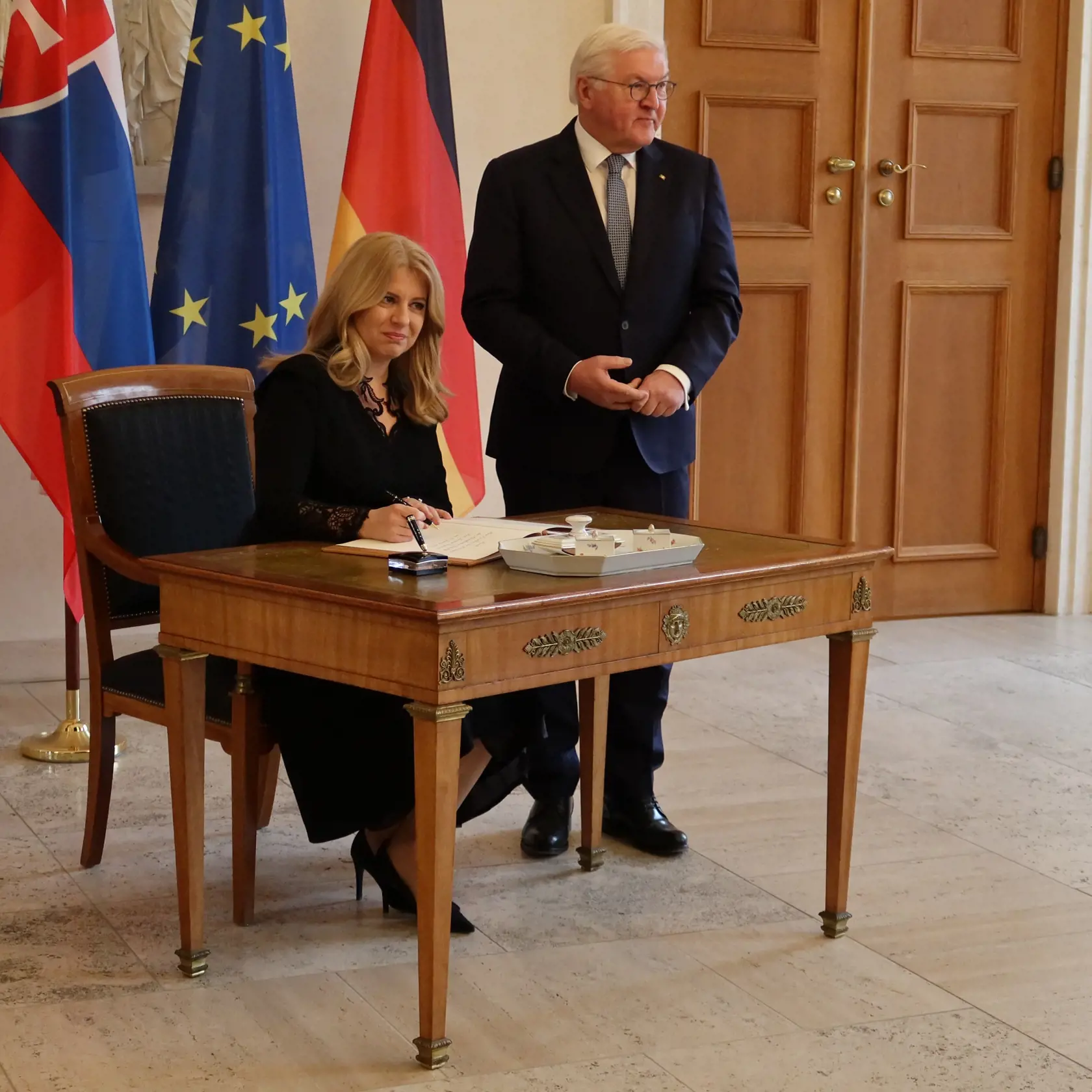 Slovenská prezidentka Zuzana Čaputová (vľavo) sa zapisuje do knihy návštev, vpravo sa prizerá nemecký prezident Frank-Walter Steinmeier počas stretnutia v Berlíne v utorok 24. januára 2023. FOTO TASR - Katarína Bačová 