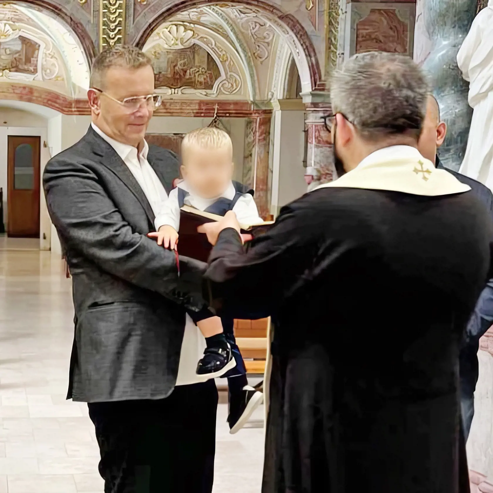 Krst. Boris Kollár so synom Abnerom, ktorého má s Laurou, na rukách.