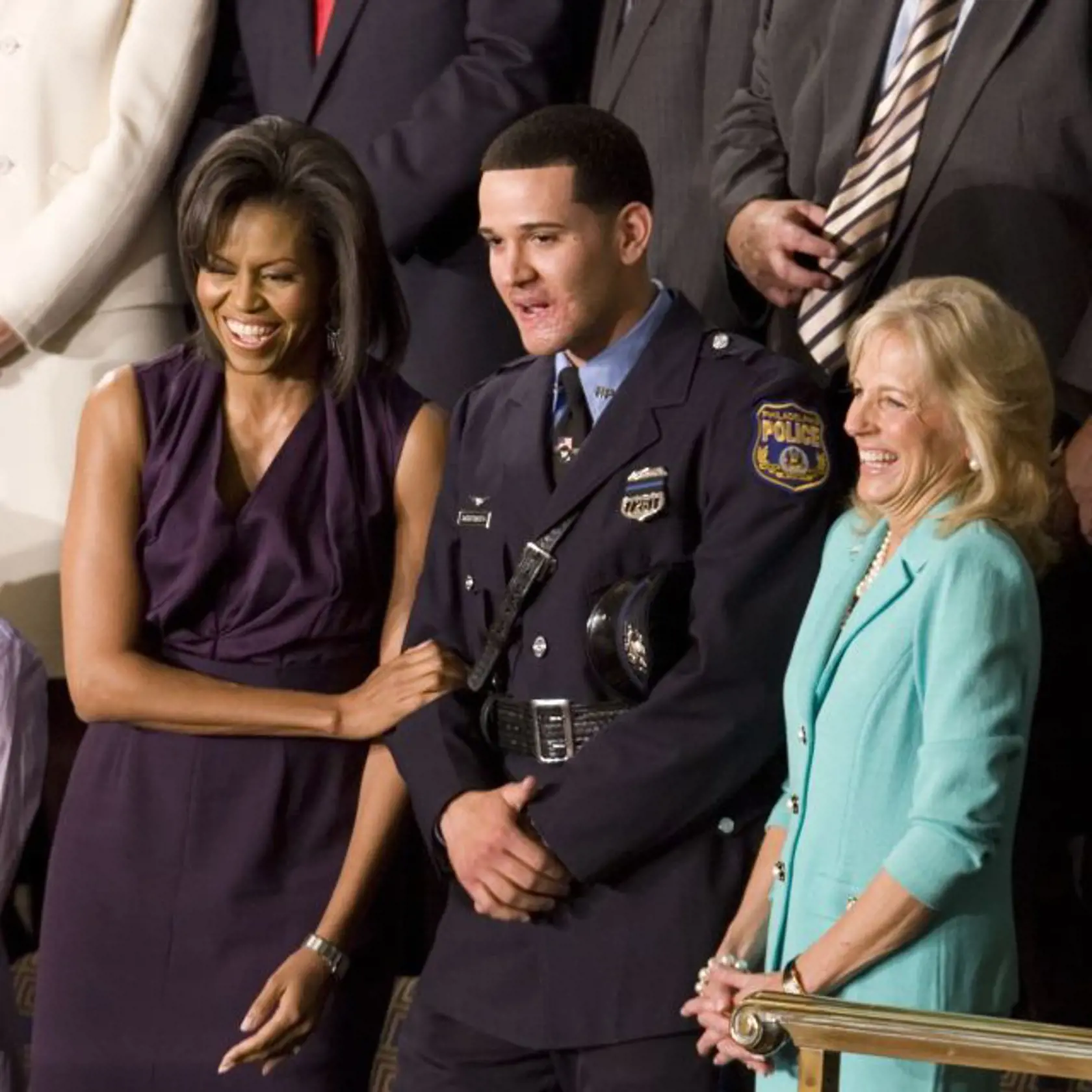 FILE - In this Tuesday, Feb. 24, 2009 file photo, first lady Michelle Obama and Jill Biden, wife of Vice President Joe Biden, stand with Philadelphia Police Officer Richard DeCoatsworth during President Barack Obama's address to a joint session of Congress in the House Chamber of the Capitol in Washington. The former Philadelphia police officer once hailed as a hero and given a seat next to the first lady at a speech by President Obama has been arrested and charged with rape and other crimes for