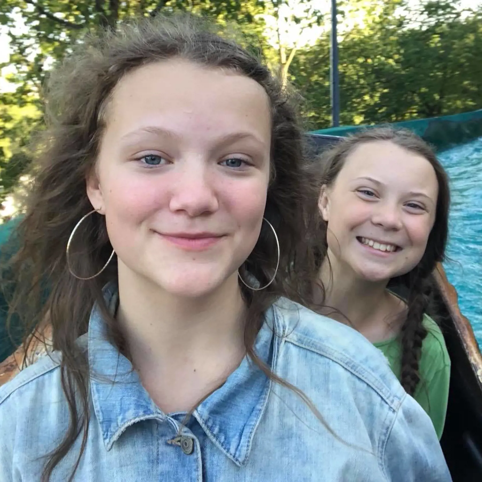 Greta Thunberg (v pozadí) so sestrou Beatou.