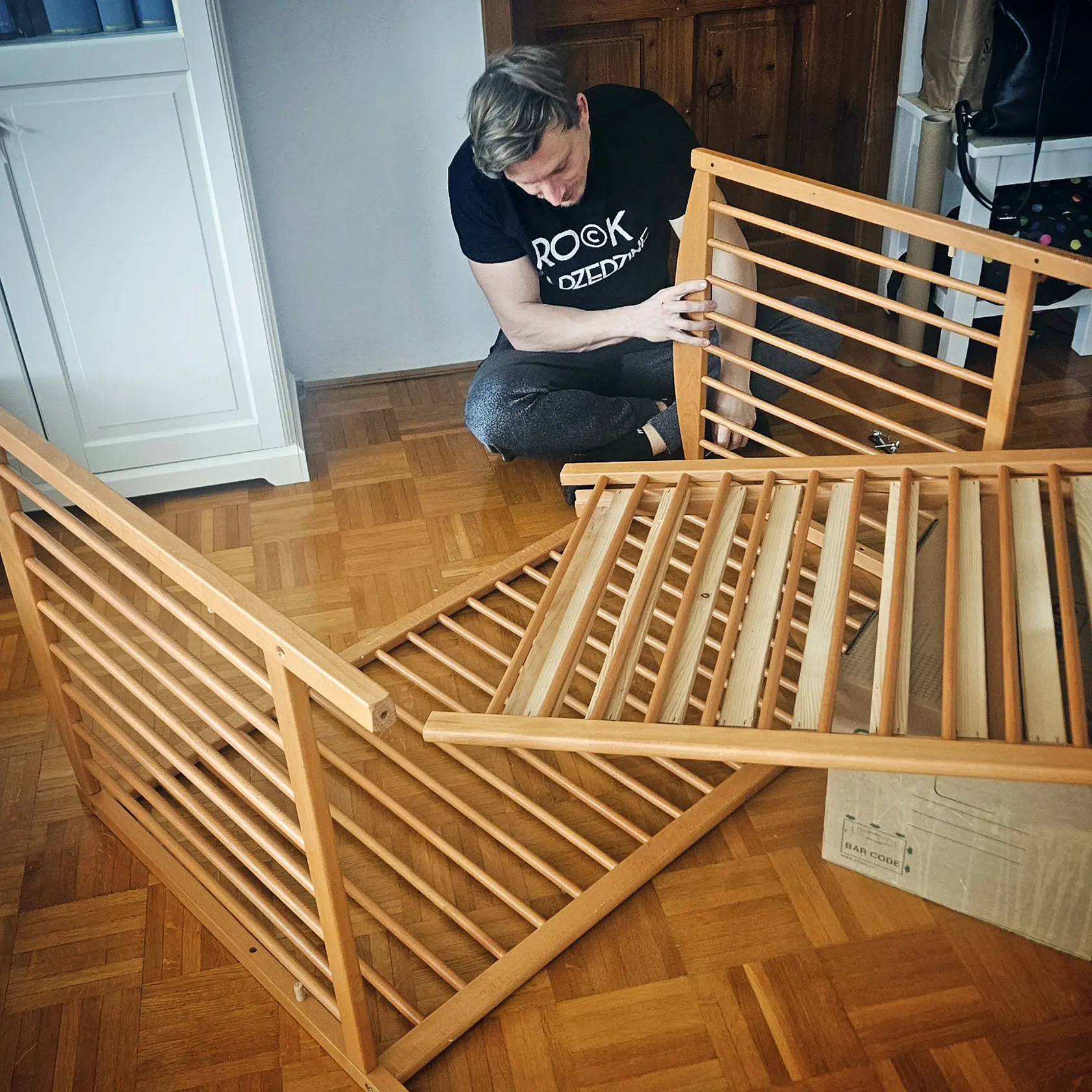 Budúci otec sa pustil do montovania postieľky.