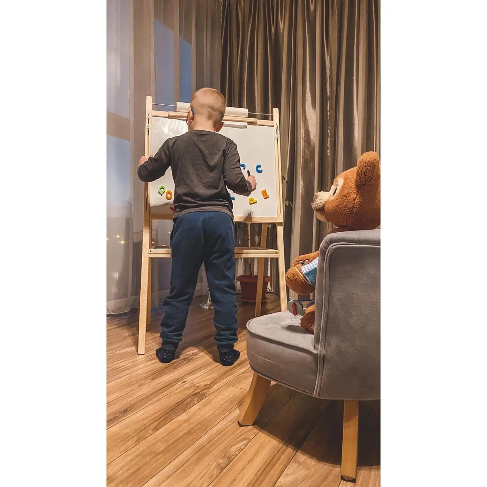 Synček Alex sa doma hrá na školu s plyšovým medveďom.