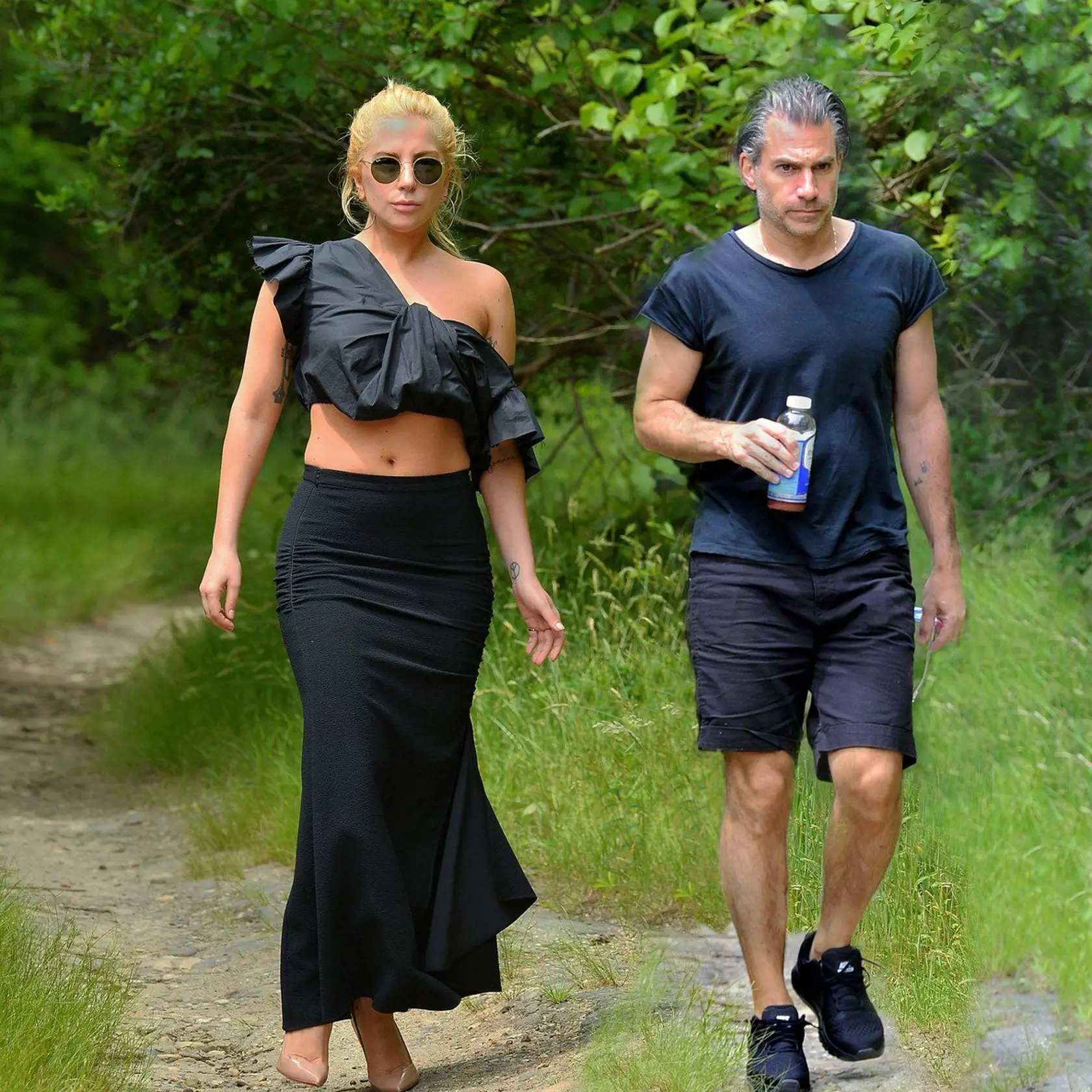 EXCLUSIVE: Lady Gaga maintains her personal style during a hike in the woods with her new boyfriend Christian Carino; rocking a black crop top and tan pumps during the walk while on vacation in Montauk, New York. Pictured: Lady Gaga, Christian Carino, Image: 338784337, License: Rights-managed, Restrictions: -ALLCOUNTRY, Model Release: no, Credit line: Profimedia, Splash