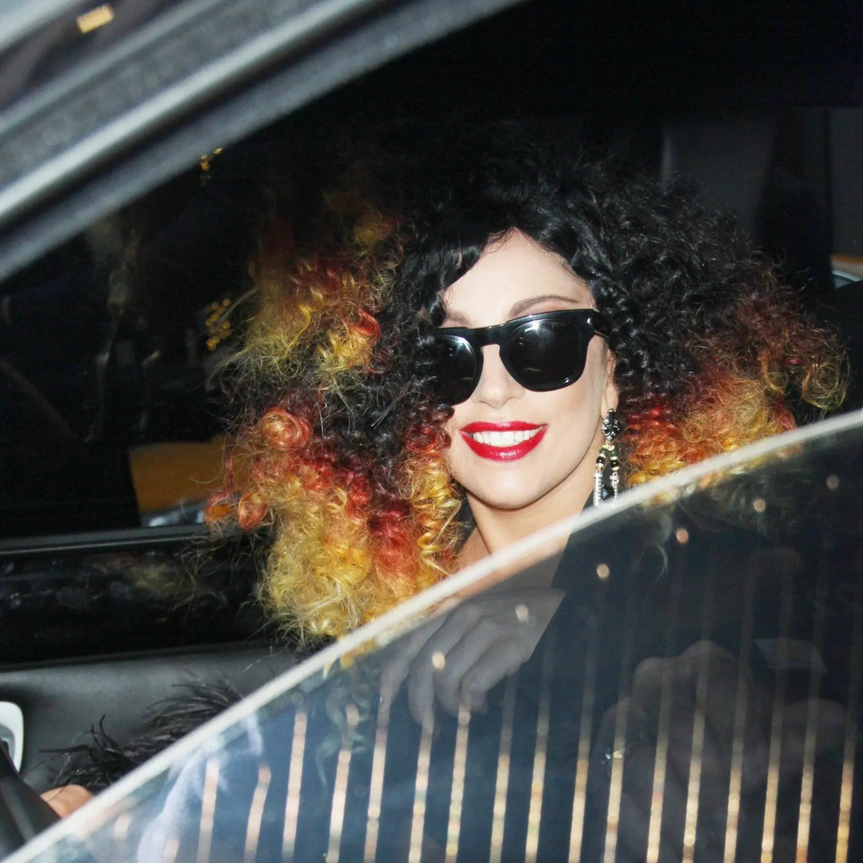 New York, NY - Following an appearance on 'The Howard Stern Show,' Lady Gaga headed out of SiriusXM Radio Studios in NYC, looking as eclectic as usual. The "Art Pop" singer donned a huge curly dyed afro wig and a feathered jacket-and-skirt number over a revealing lace bralette.                    December 2, 2014, Image: 212195060, License: Rights-managed, Restrictions: NO Brazil, Model Release: no, Credit line: Profimedia, AKM-GSI