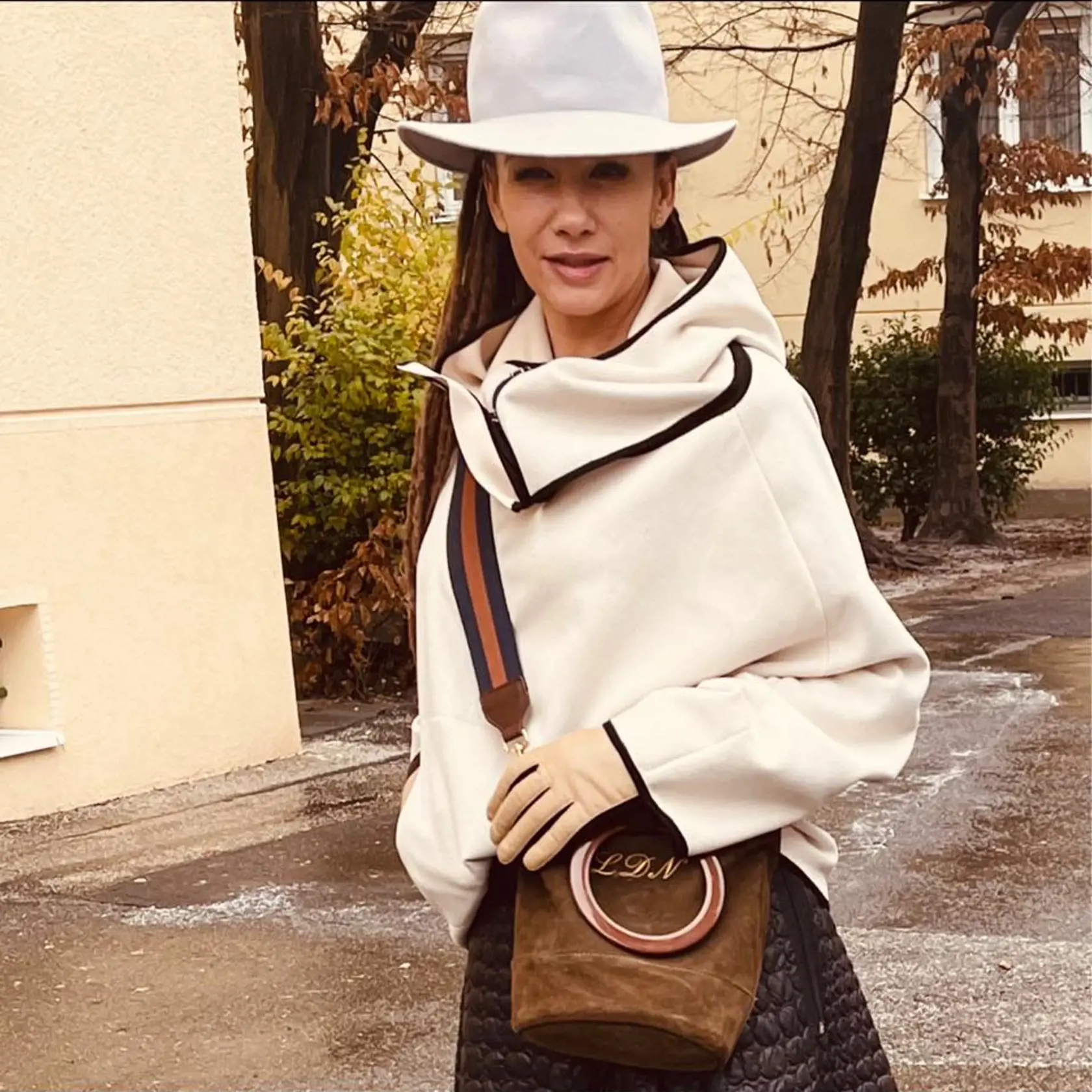 Rovnaký outfit - pončo, prešívaná sukňa a crossbody kabela a samozrejme, že nechýba ani klobúk.
