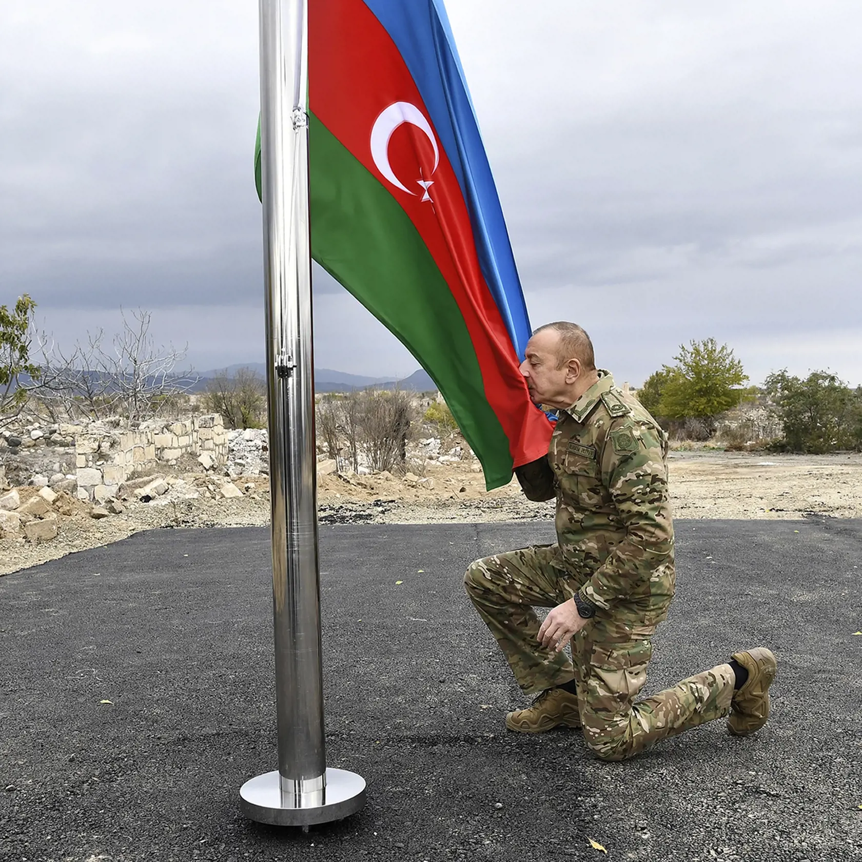 Azerbajdžanský prezident Ilham Alijev bozkáva národnú zástavu počas jeho návštevy v azerbajdžanskom meste Aghdam, v samozvanom regióne Náhorný Karabach 23. novembra 2020 po tom, ako azerbajdžanská armáda vstúpila do prvého okresu odovzdaného Arménmi.