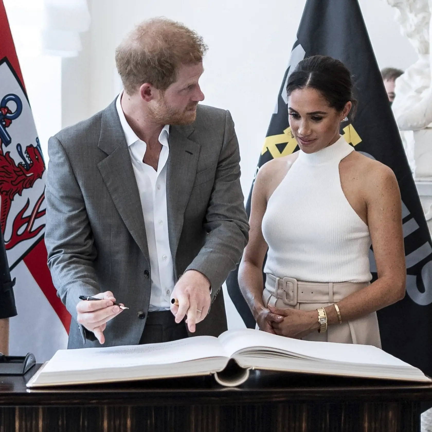 Britský princ Harry a Meghan, vojvodkyňa zo Sussexu, sa zapisujú do knihy hostí počas návštevy v radnici nemeckého mesta Düsseldorf.
