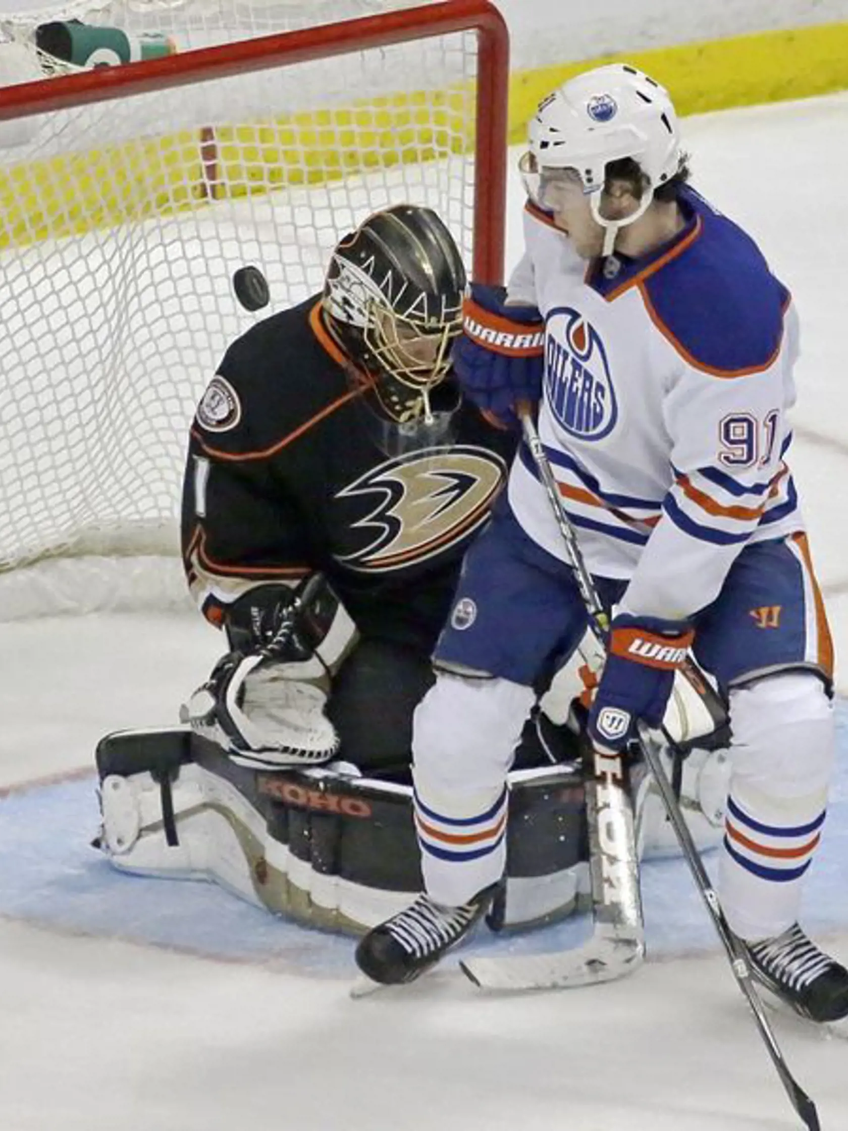 Gólman Anaheimu Jonas Hiller dostáva v dueli s Edmontonom gól. Vo výhľade mu cloní Magnus Pääjärvi.