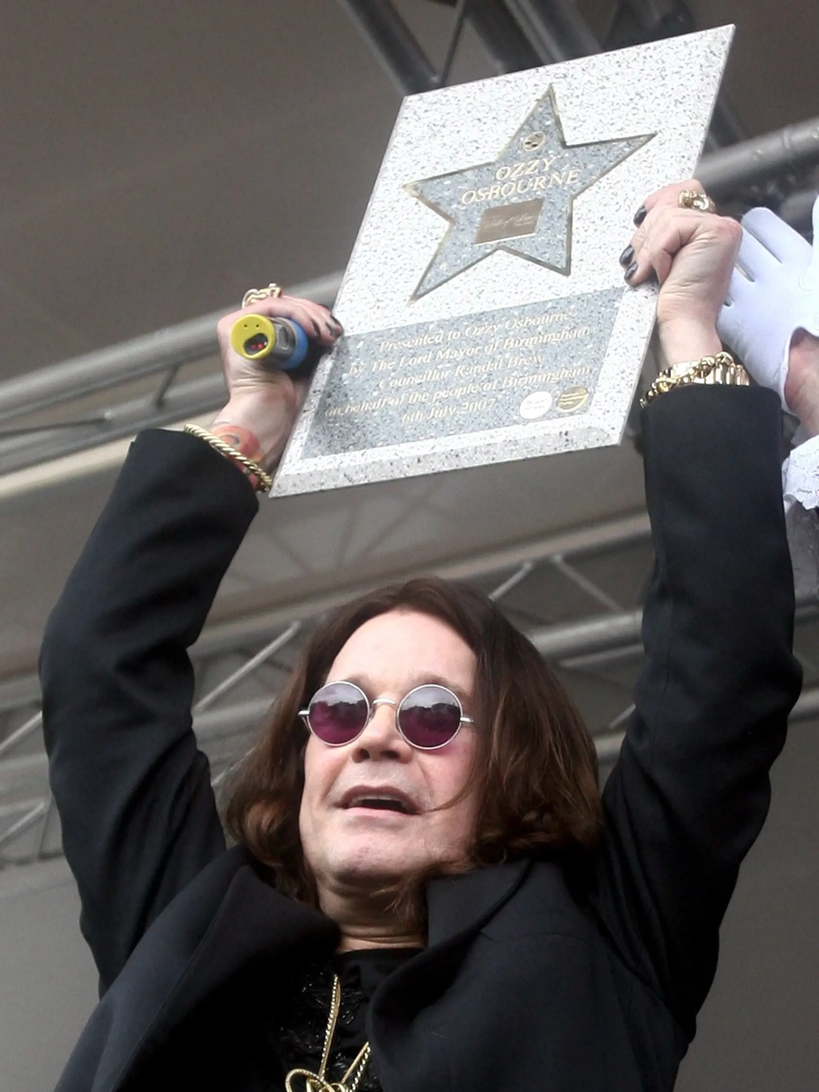 Na archívnej snímke Ozzy Osbourne dvíha repliku svojej hviezdy, ktorú ako prvý upevní na Chodníku slávy hollywoodskeho štýlu v Birminghame 6. júla 2007.
