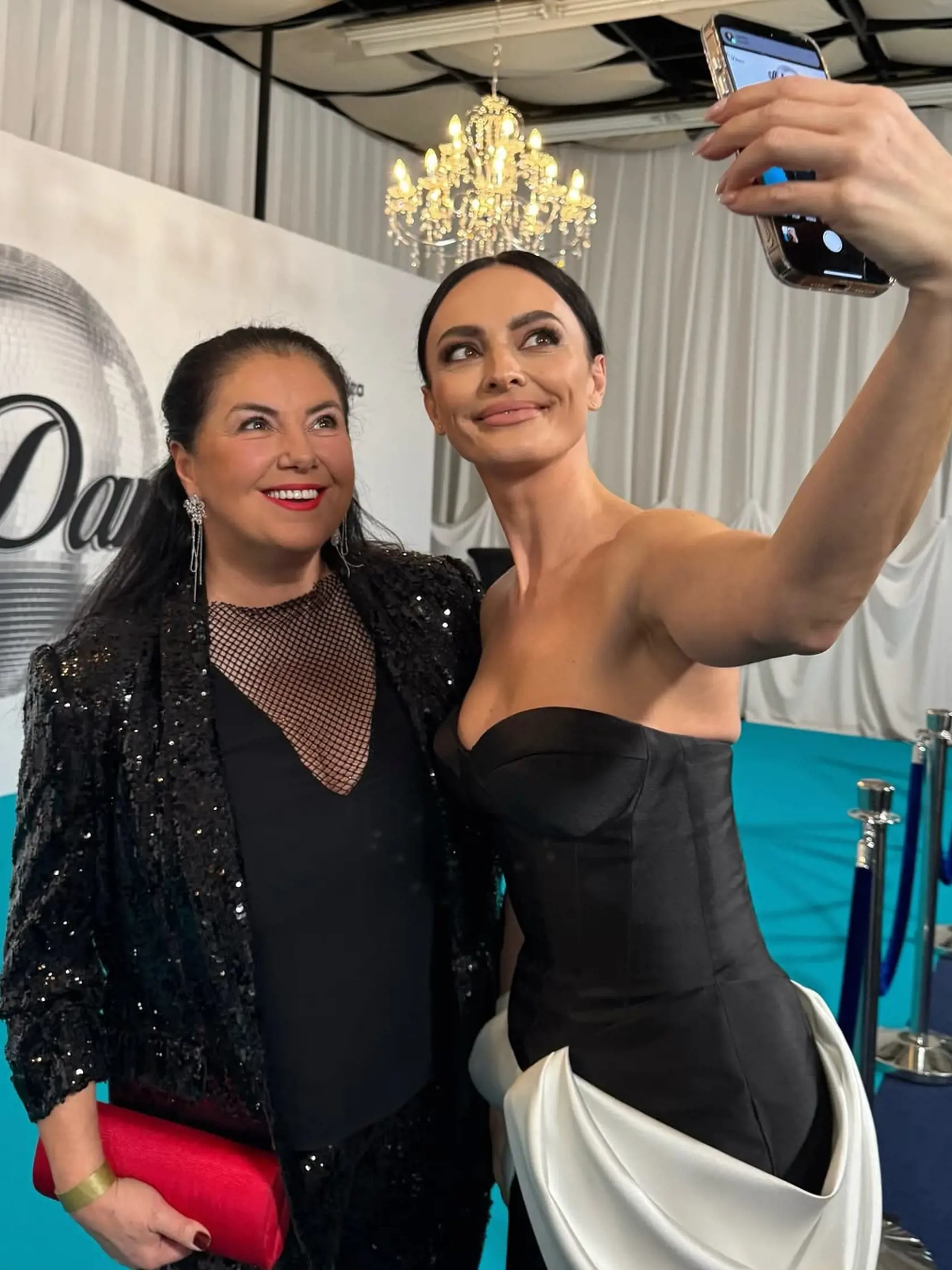 2. kolo Let's Dance: Na snímke Iveta Malachovská, ktorá sa predviedla v priesvitnom tope a ligotavom saku. Selfie s ňou si robí módna stylistka a influencerka Mirka Dobiš alias FashionSpy. 