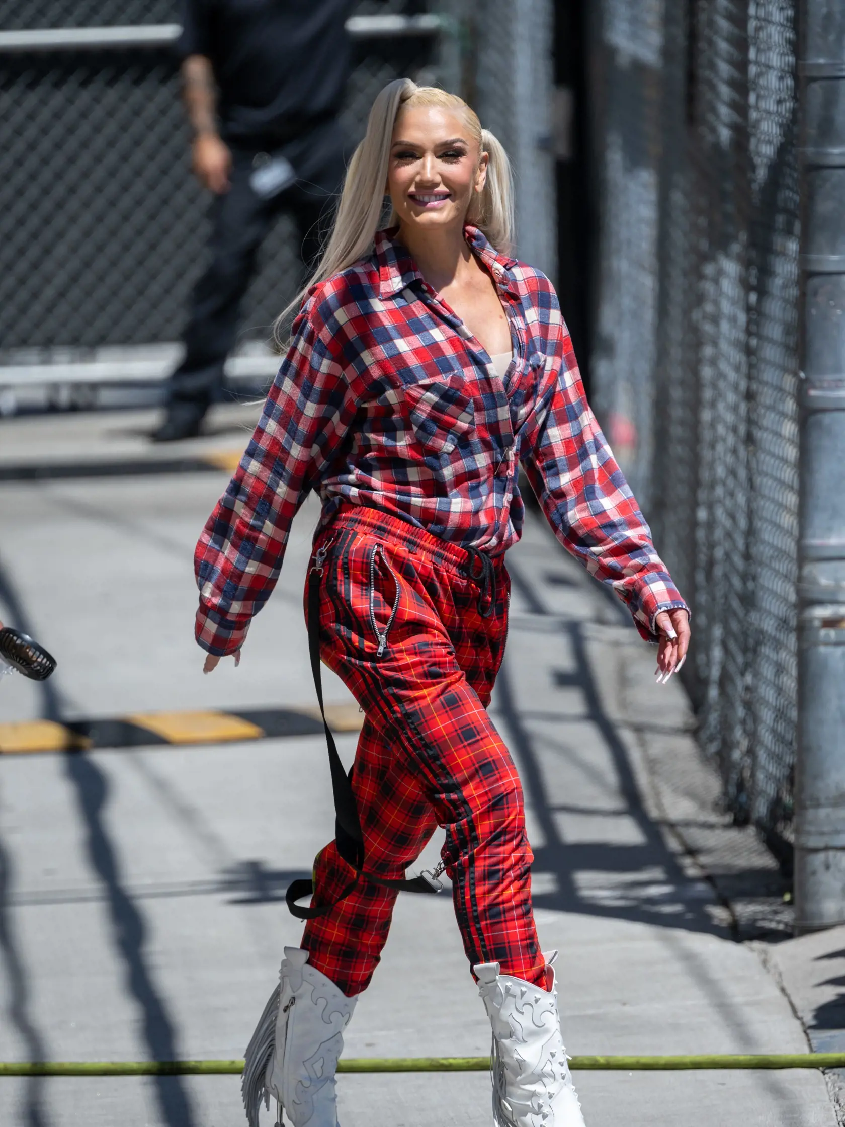 Gwen Stefani sa takto vystrojila na nakrúcanie Live Show Jimmyho Kimmela. Vlasy vyčesané do viacerých konských chvostov a nápadný károvaný outfit zaklincovaný bielymi kovbojskými čižmami… A pozrite na tie podpätky, tie sú fakt za trest, uf!