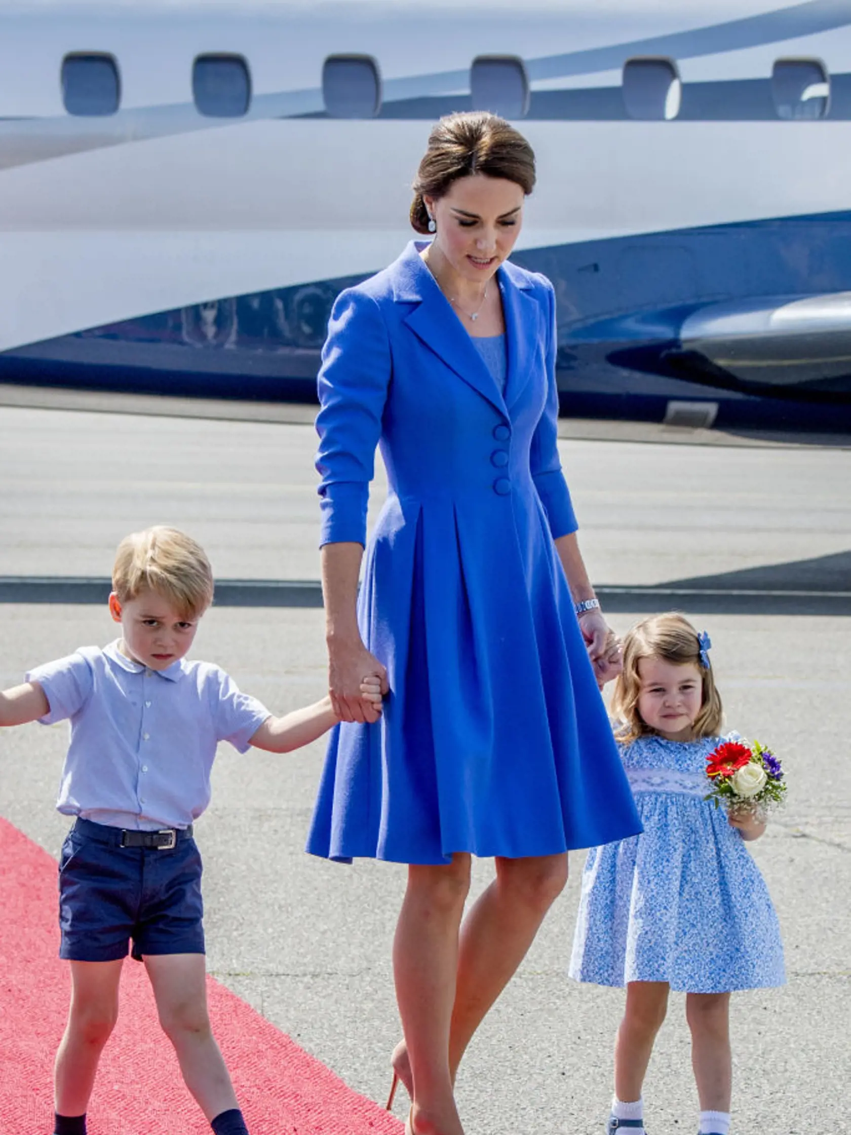 BERLIN, GERMANY - JULY 19:  Catherine, Duchess of Cambridge with Prince George of Cambridge and Princess Charlotte of Cambridge as they arrive at Berlin Tegel Airport during an official visit to Poland and Germany on July 19, 2017 in Berlin, Germany.  (Photo by Robin Utrecht - Pool/Getty Images)