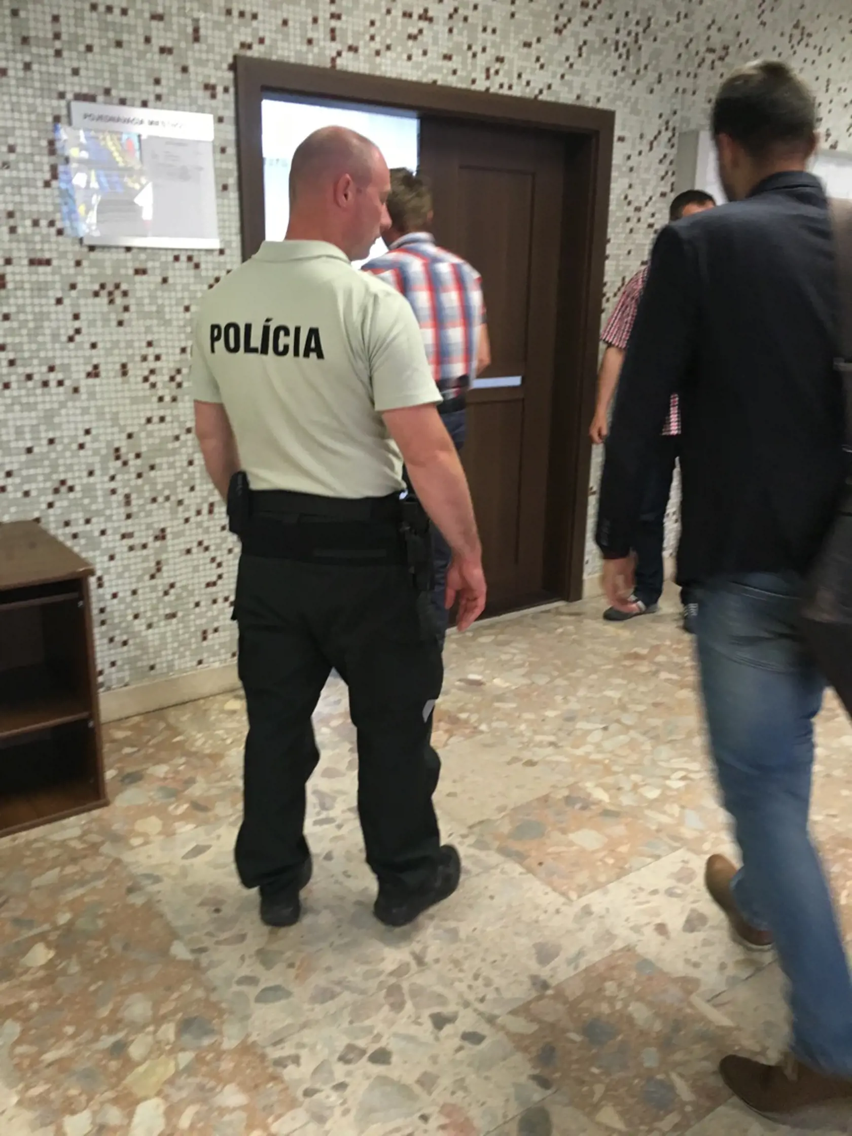 Pri vstupe do pojednávacej miestnosti.