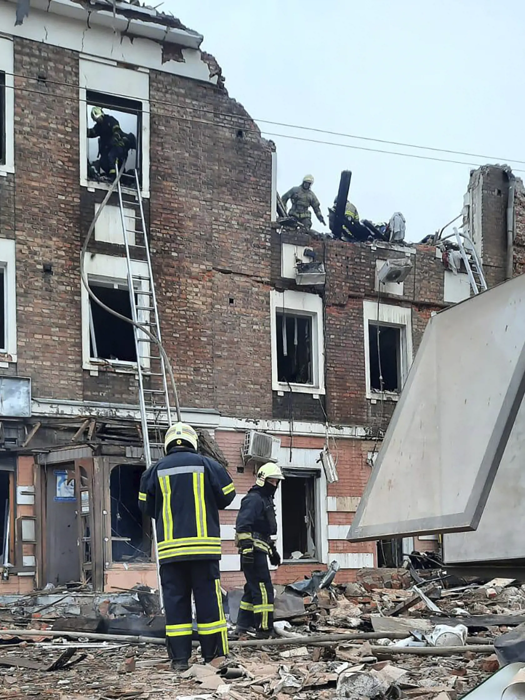 Príslušníci záchranných zložiek pátrajú po obetiach, ktoré prišli o život po raketovom útoku ruskej armády na viacposchodovú budovu v Charkove v piatok 6. októbra 2023.