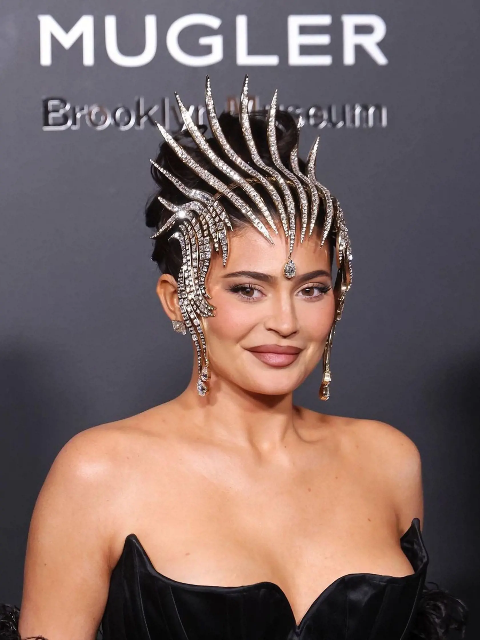 Kylie, ktorá vo februári porodila druhé dieťa, zaujala v čiernych korzetových šatách zvýrazňujúcich jej dokonalú postavu presýpacích hodín. Ale skutočnou čerešničkou na torte bola ozdobná diamantová korunka.