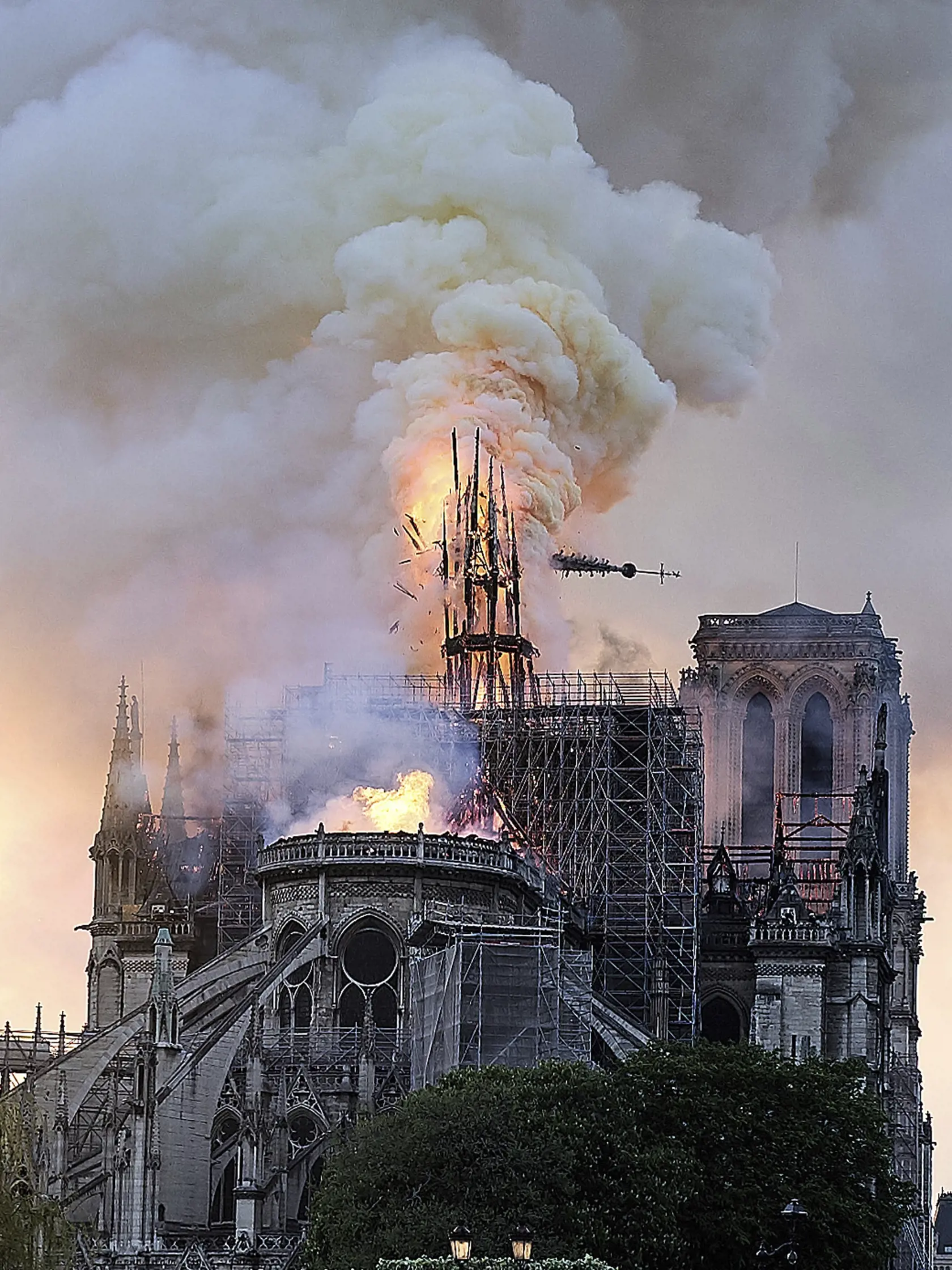 SY 10 Paríž - Na snímke padá sanktusník - štíhla vežičke nad presbytériom kostola na hrebeni strechy hlavnej chrámovej lode počas požiaru Katedrály Notre Dame 15. apríla 2019 v Paríži. Požiar, ktorý vypukol v katedrále pár minút pred 19. hodinou zničil strechu 850-ročného chrámu. Takmer štyrom stovkám hasičov sa podarilo po polnoci požiar dostať pod kontrolu. Oheň vypukol pravedepodobne v súvislosti s renovačnými prácami. FOTO TASR/AP
Flames and smoke rise as the spire on Notre Dame cathedral co