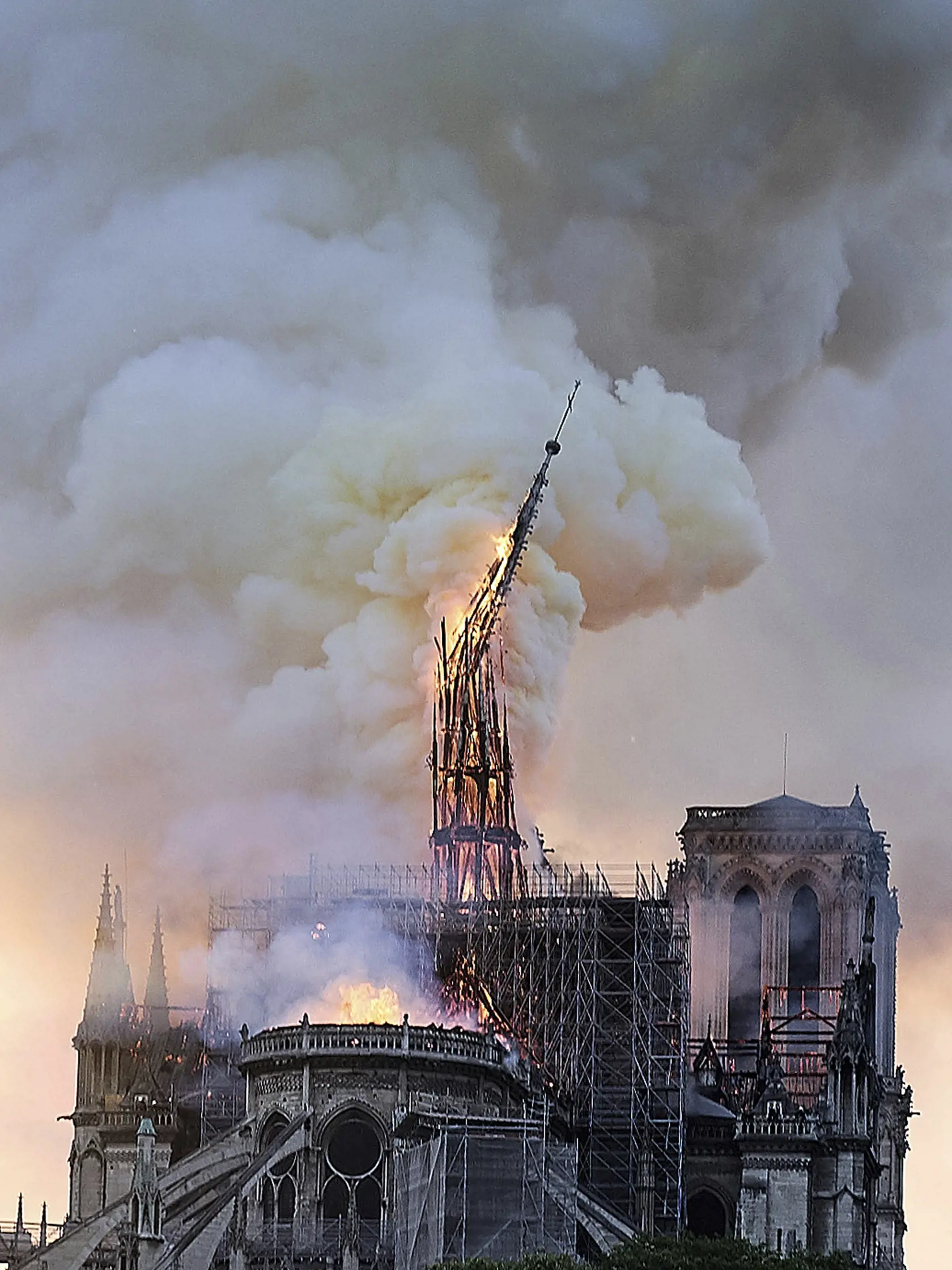 SY 8 Paríž - Na snímke padá sanktusník - štíhla vežičke nad presbytériom kostola na hrebeni strechy hlavnej chrámovej lode počas požiaru Katedrály Notre Dame 15. apríla 2019 v Paríži. Požiar, ktorý vypukol v katedrále pár minút pred 19. hodinou zničil strechu 850-ročného chrámu. Takmer štyrom stovkám hasičov sa podarilo po polnoci požiar dostať pod kontrolu. Oheň vypukol pravedepodobne v súvislosti s renovačnými prácami. FOTO TASR/AP
Flames and smoke rise as the spire on Notre Dame cathedral col
