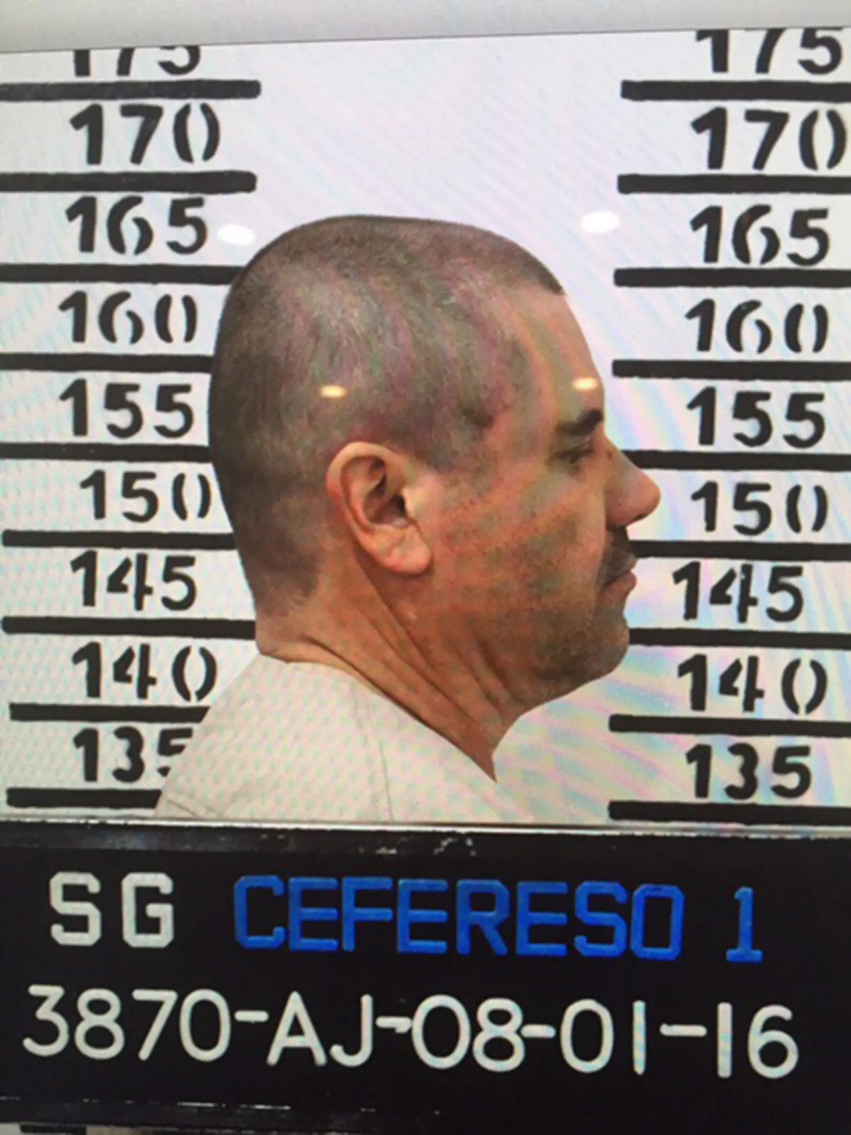 In this Jan. 8, 2016 image released by Mexico's federal government, Mexico's most wanted drug lord, Joaquin "El Chapo" Guzman, stands for his prison mug shot, with the inmate number 3870, at the Altiplano maximum security federal prison in Almoloya, Mexico. Mexico has begun the process of extraditing Guzman to the United States, where he faces drug-trafficking charges, but that could take "a year or longer" because of legal challenges, said the head of Mexico's extradition office, Manuel Merino.