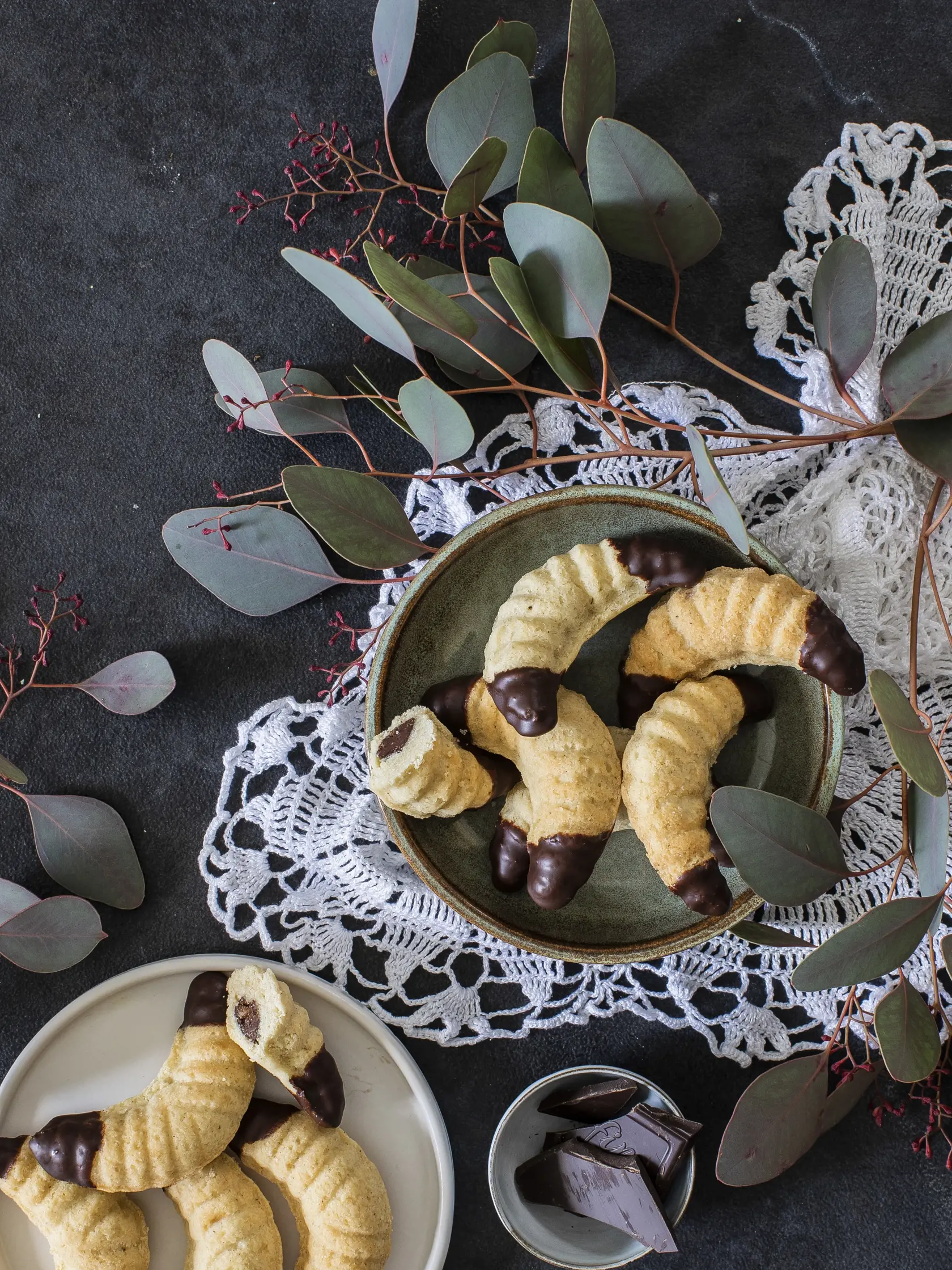 vanilkové rožky

recept:
25 KUSOV, PRÍPRAVA 35 MINÚT, PEČENIE 13 AŽ 15 MINÚT, CHLADENIE
Na cesto:
• 320 g hladkej múky • 200 g masla • 80 g práškového cukru
• 1 lyžička mletej vanilky • 2 žĺtky
Na obaľovanie:
• 100 g práškového cukru • 1 lyžička mletej vanilky
Na náplň:
• 100 g tmavej čokolády 54 % • 1 lyžica medu • 65 g mletých lieskových orieškov
Na namáčanie:
• 150 g tmavej čokolády 54 % • 20 g masla
1. Múku s maslom, cukrom, vanilkou a so žĺtkami premiešajte a vypracuj- te hladké cesto. Cesto zabaľte do fólie a odložte do chladničky na dve hodiny.
2. Formičky na rožteky jemne vymas- tite maslom a do každej vložte kúsok cesta. Cesto dobre zatlačte po okraj formičky. Tie poukladajte na plech
a vložte do rúry vyhriatej na 200 °C. Pečte 13 až 15 minút.
3. Nechajte 5 minút vychladnúť
a rožteky opatrne vyklopte z for- mičiek. Ešte teplé ich obaľte vo vanilkovom cukre, ktorý si pripra- víte zmiešaním práškového cukru
a mletej vanilky. Vychladnuté rožteky skladujte v uzavretej nádobe.

 1. Pripravte si cesto na rož- teky, a kým sa chladí, urobte si náplň. Čokoládu roztopte nad vodnou parou, pridaj- te med a mleté lieskové oriešky. Dobre rozmiešajte, aby ste získali hustejšiu pastu. Pastu preložte do cukrárskeho vrecka a od- strihnite špičku.
2. Oddýchnuté cesto vyber- te z chladničky. Do formičky vložte menší kúsok cesta, roztľapkajte ho na dno
a boky formičky, do stredu cesta pomocou vrecka vytlačte malý valček náplne a prikryte ďalším kúskom cesta.
3. Formičky vložte do rúry vyhriatej na 200 °C a pečte 13 až 15 minút. Nechajte chvíľu vychladnúť a rožteky vyklopte. Nechajte vychlad- núť. Nakoniec konce rožkov namočte do čokolády, ktorú ste spolu s maslom roztopili nad parou. 