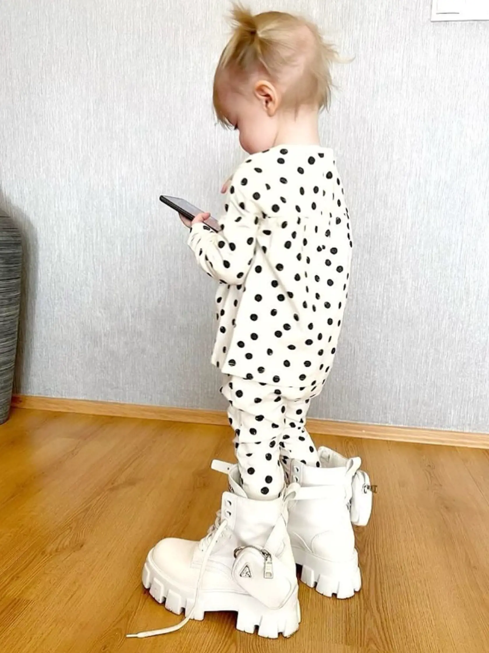 "Zatiaľ čo ´mam´ pripravuje Smotánku, náš miláčik skúša, ako sa chodí v maminých topánkach," napísala Erika k dcérkinej fotke.